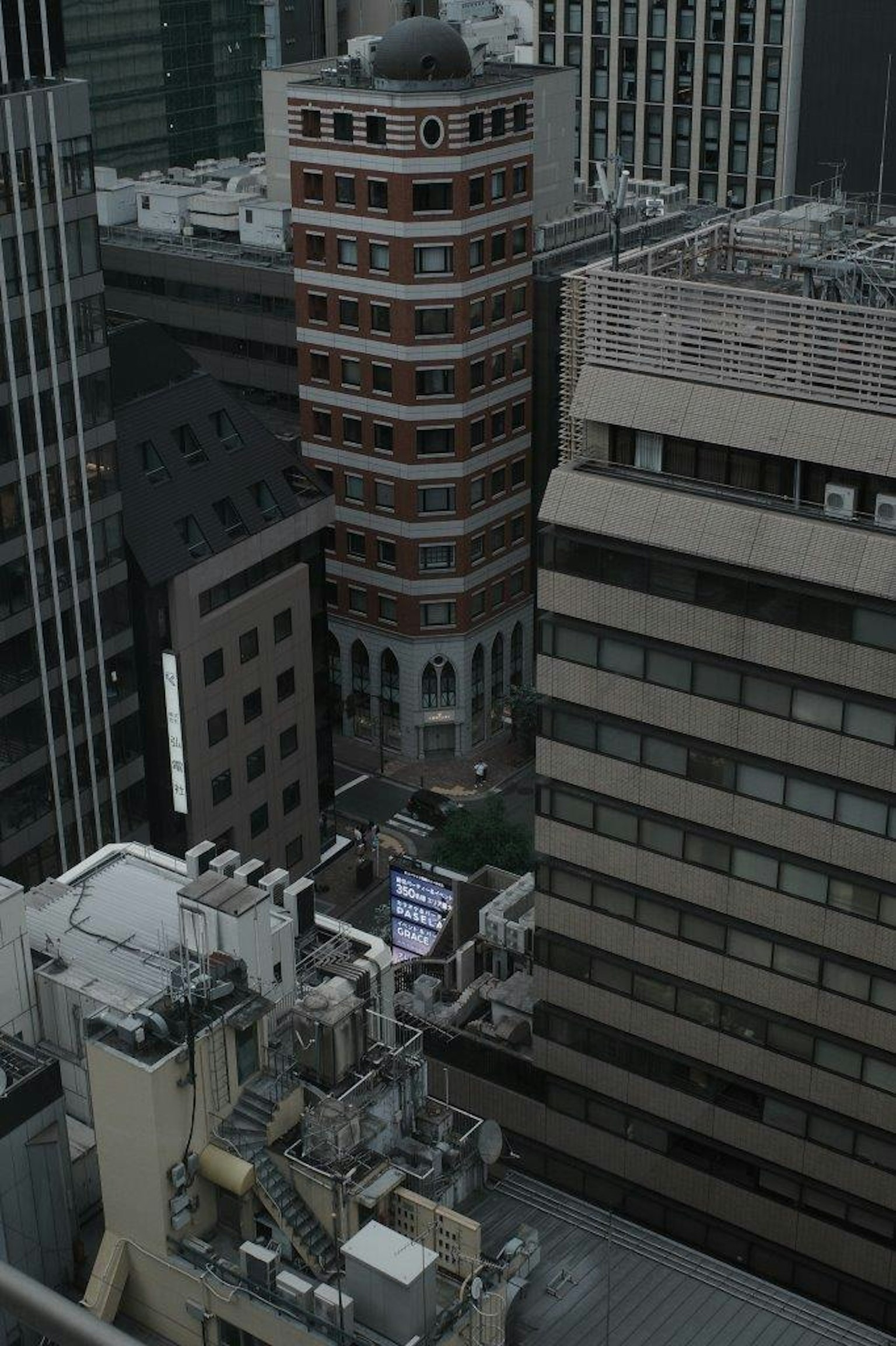 Bâtiment en brique rouge unique niché entre des gratte-ciel modernes