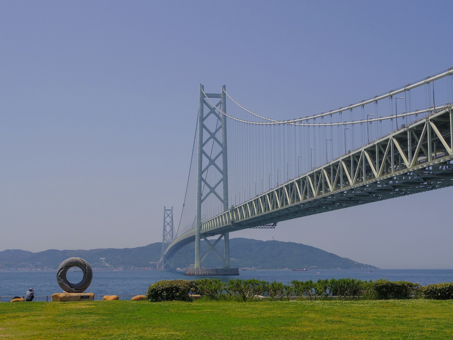 Jembatan Seto Ohashi dengan latar belakang laut dan rumput hijau