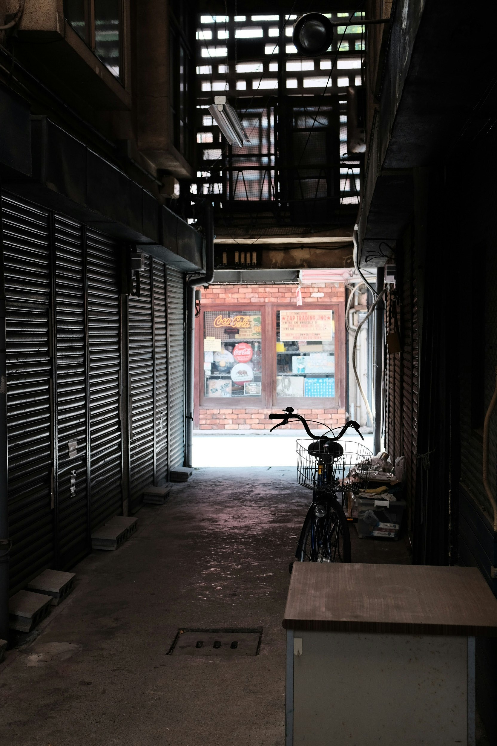 路地のような通路に並ぶシャッターと自転車