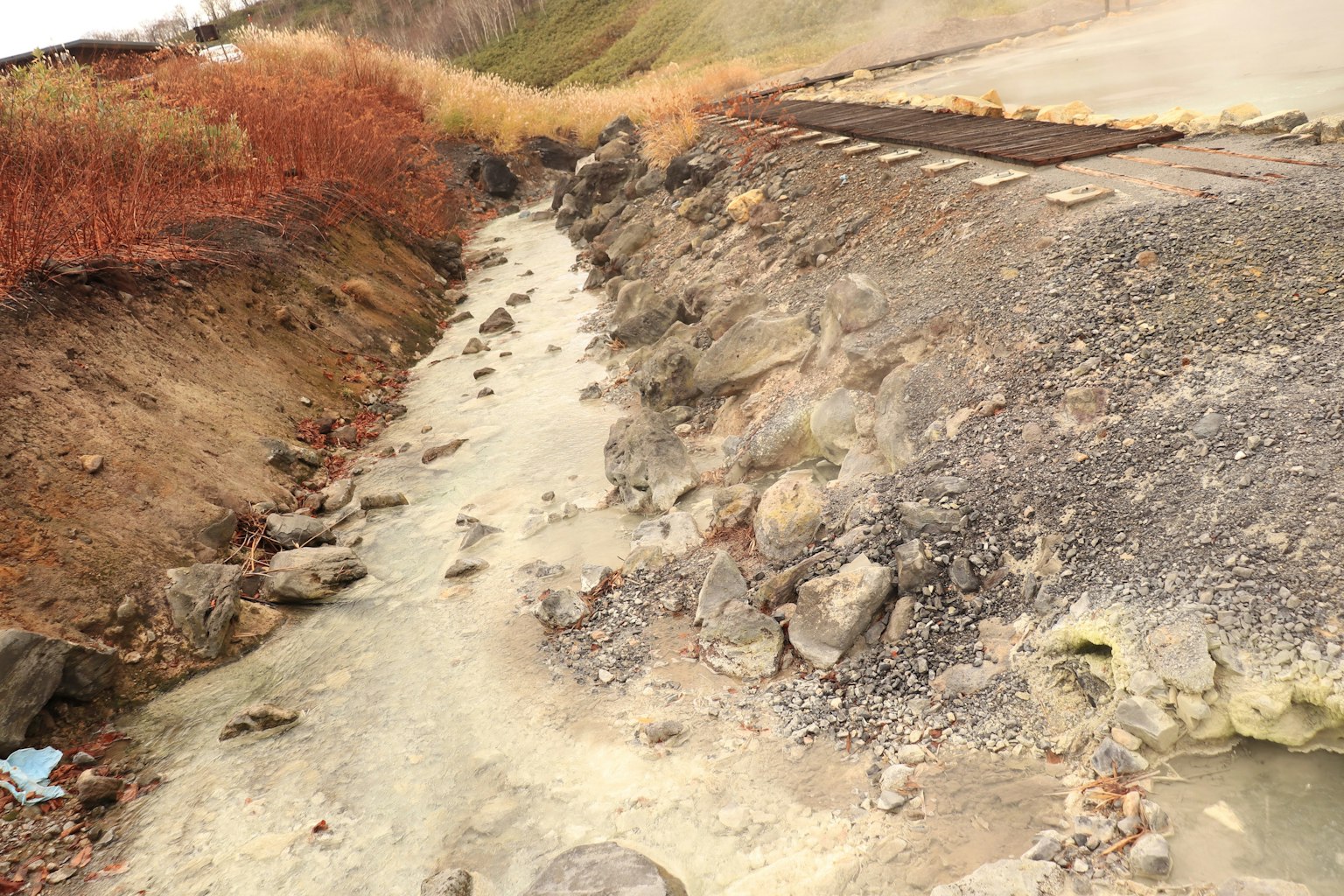Un paesaggio accidentato con un piccolo ruscello e rocce sparse