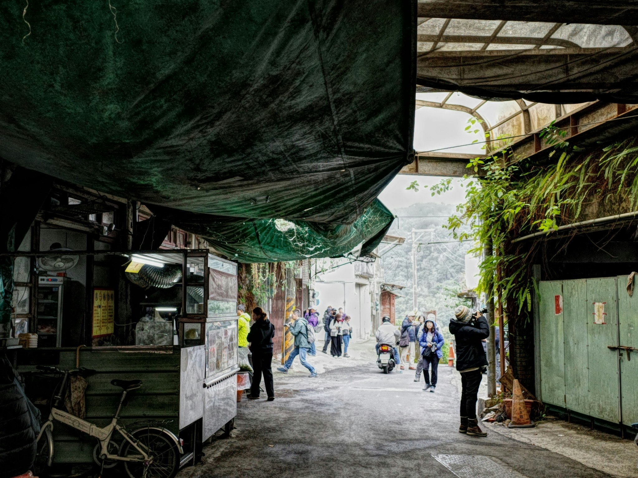 ruelle commerçante sous une toile verte