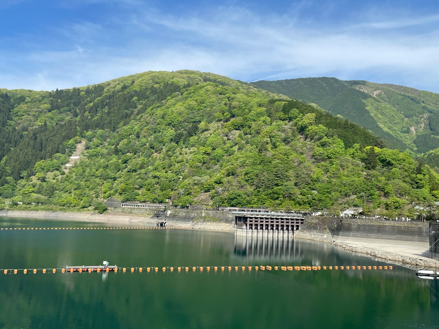 Vista panoramica di una diga circondata da colline verdeggianti e acqua calma