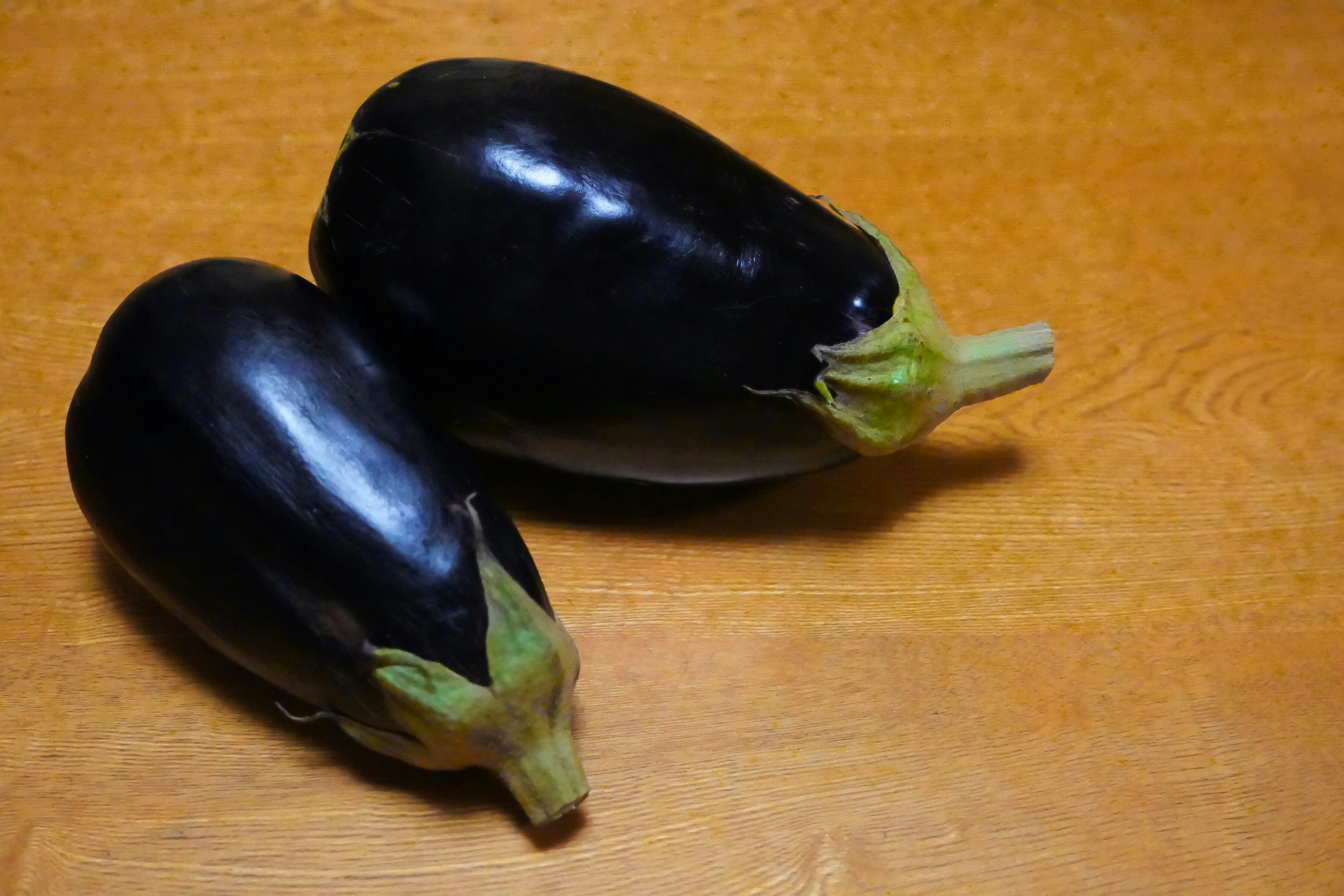 木のまな板の上に並ぶナス