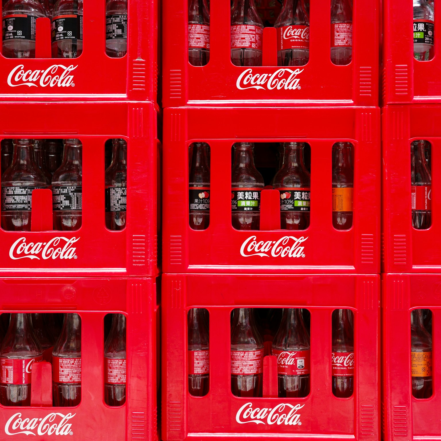 Cajas rojas de Coca-Cola apiladas mostrando varias bebidas