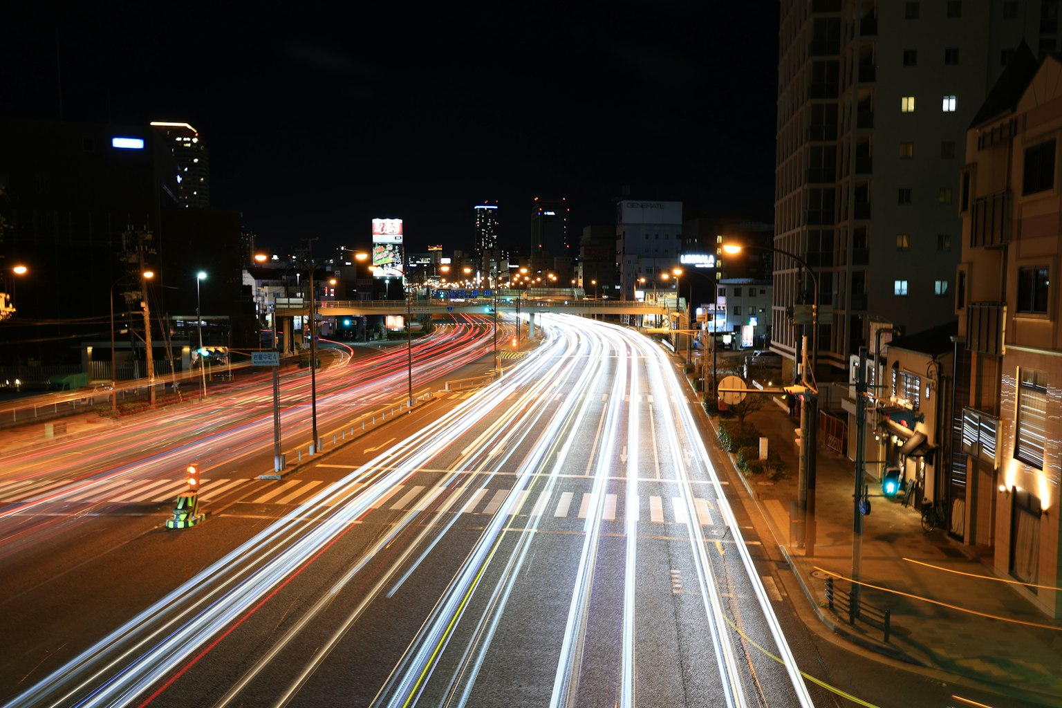 Photo à longue exposition d'une autoroute urbaine la nuit avec des lumières de voiture qui s'écoulent