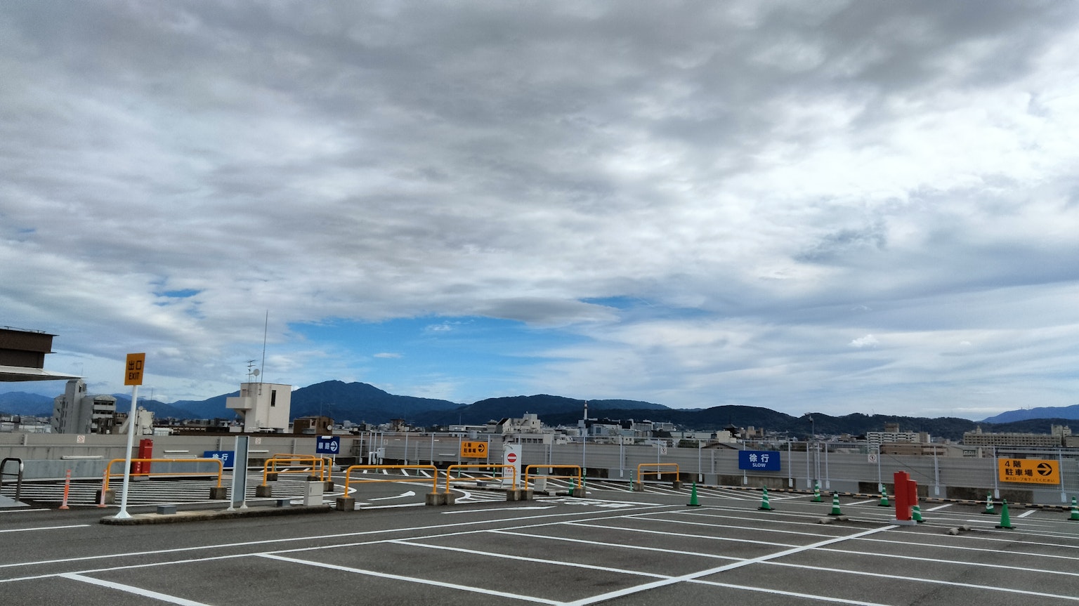 屋顶停车场的景色 阴云密布的天空和背景中的山脉