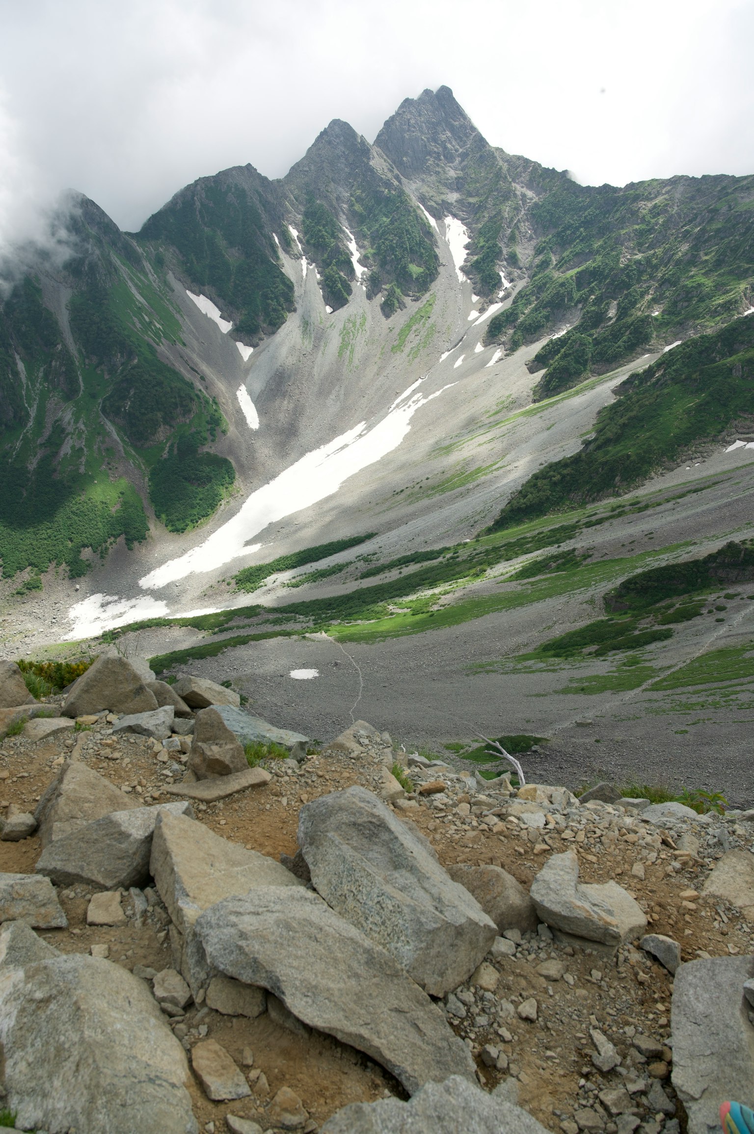 Scenic view of a mountain valley with melting snow and rocky terrain