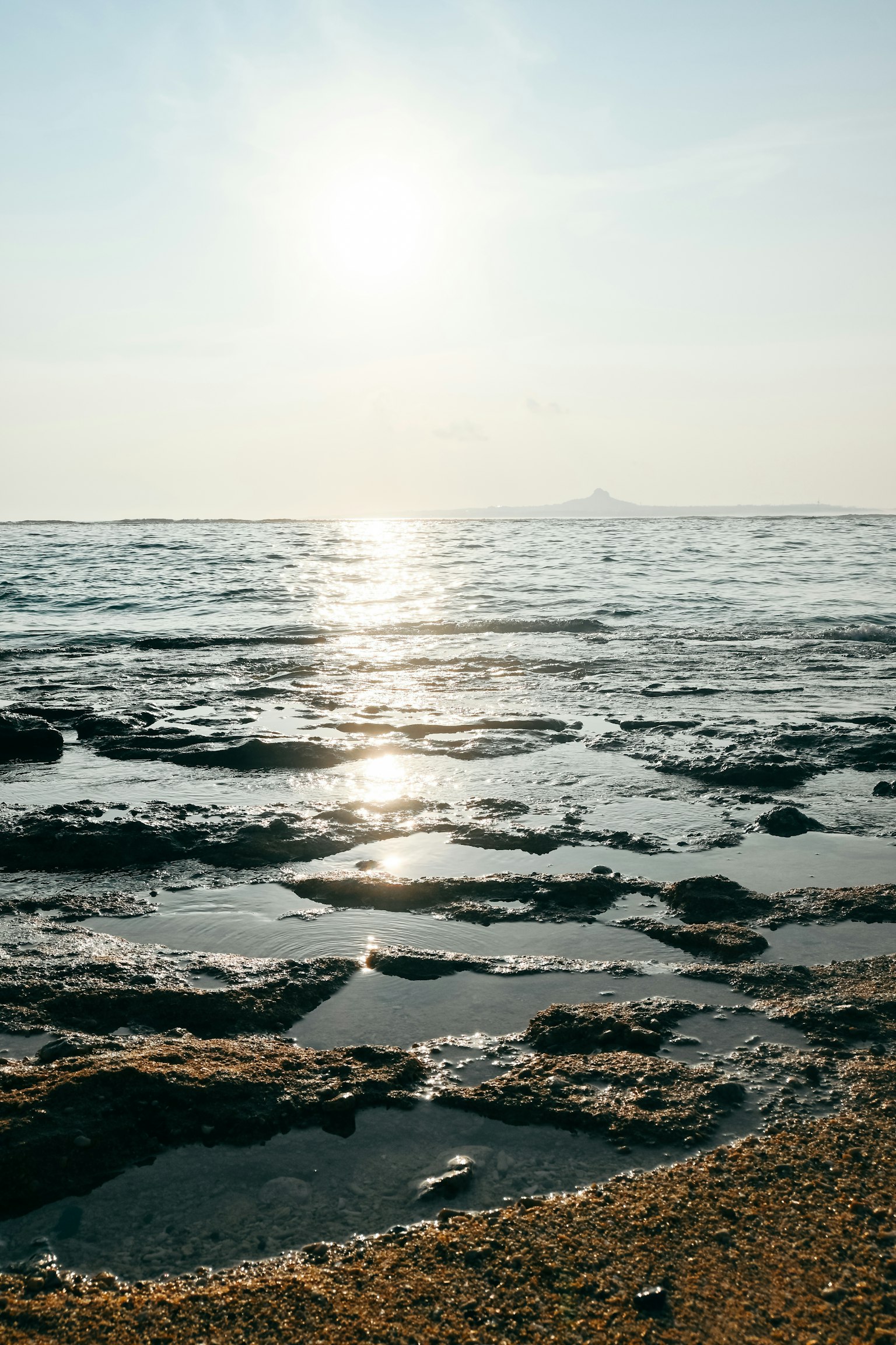 Rochers côtiers avec la lumière du soleil se reflétant sur la surface de l'eau