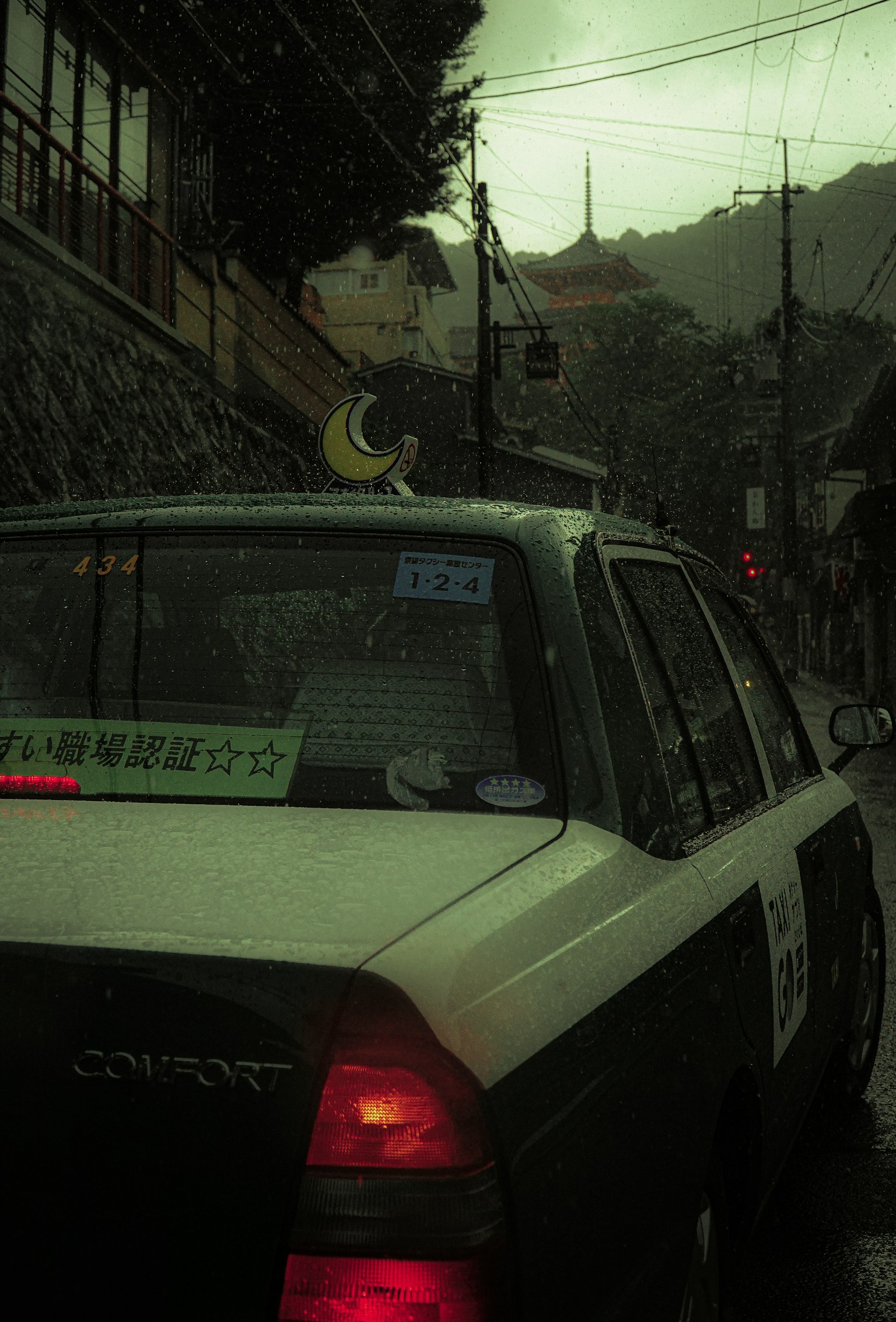 雨天街道场景中的出租车后部有月亮装饰