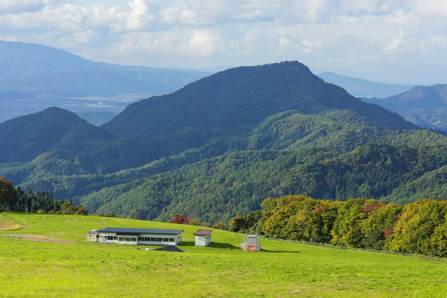 ทิวทัศน์ที่สวยงามของเนินเขาและภูเขาพร้อมอาคารในภูมิทัศน์ที่เขียวขจี