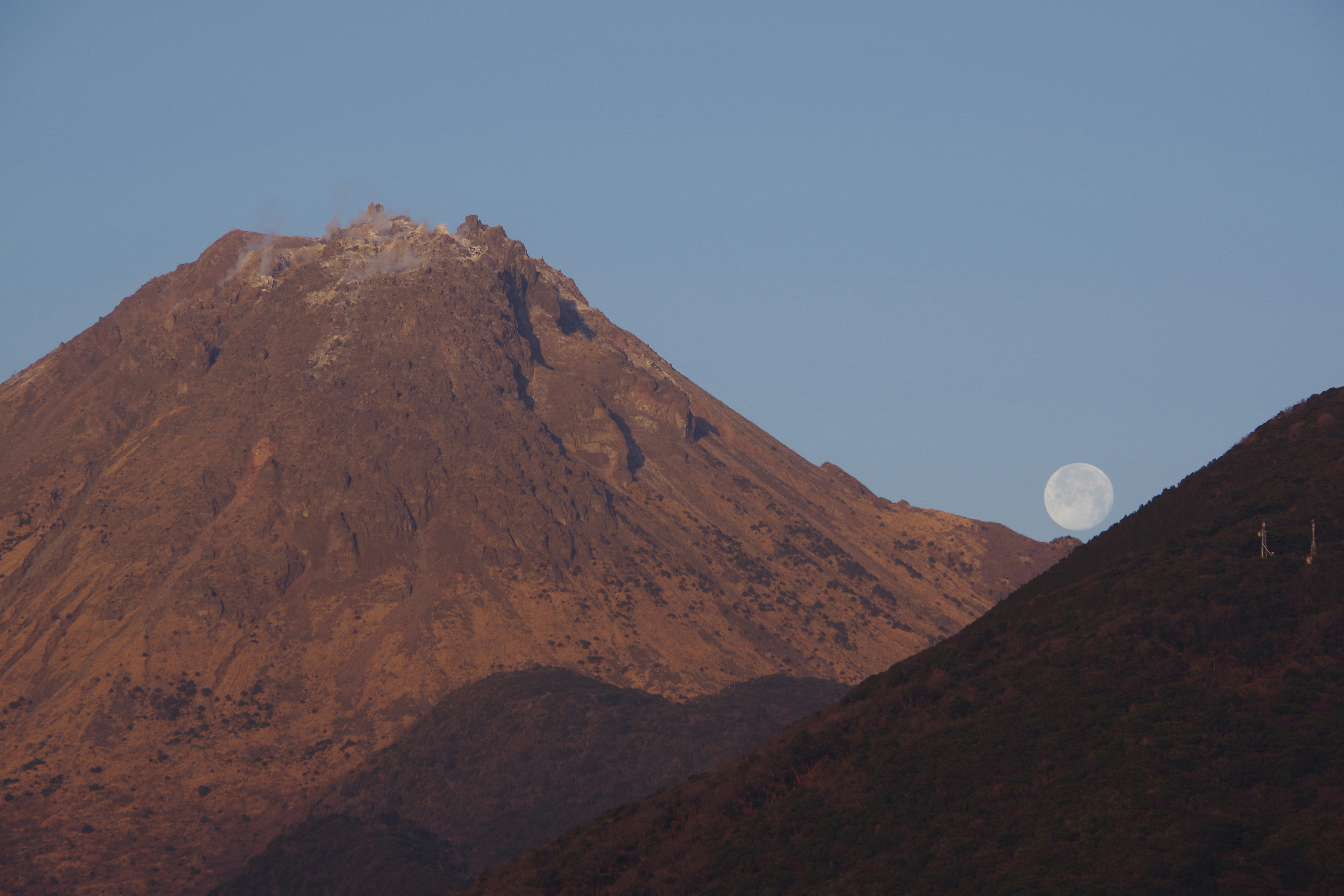 夕暮れの山稜と稜線に浮かぶ月