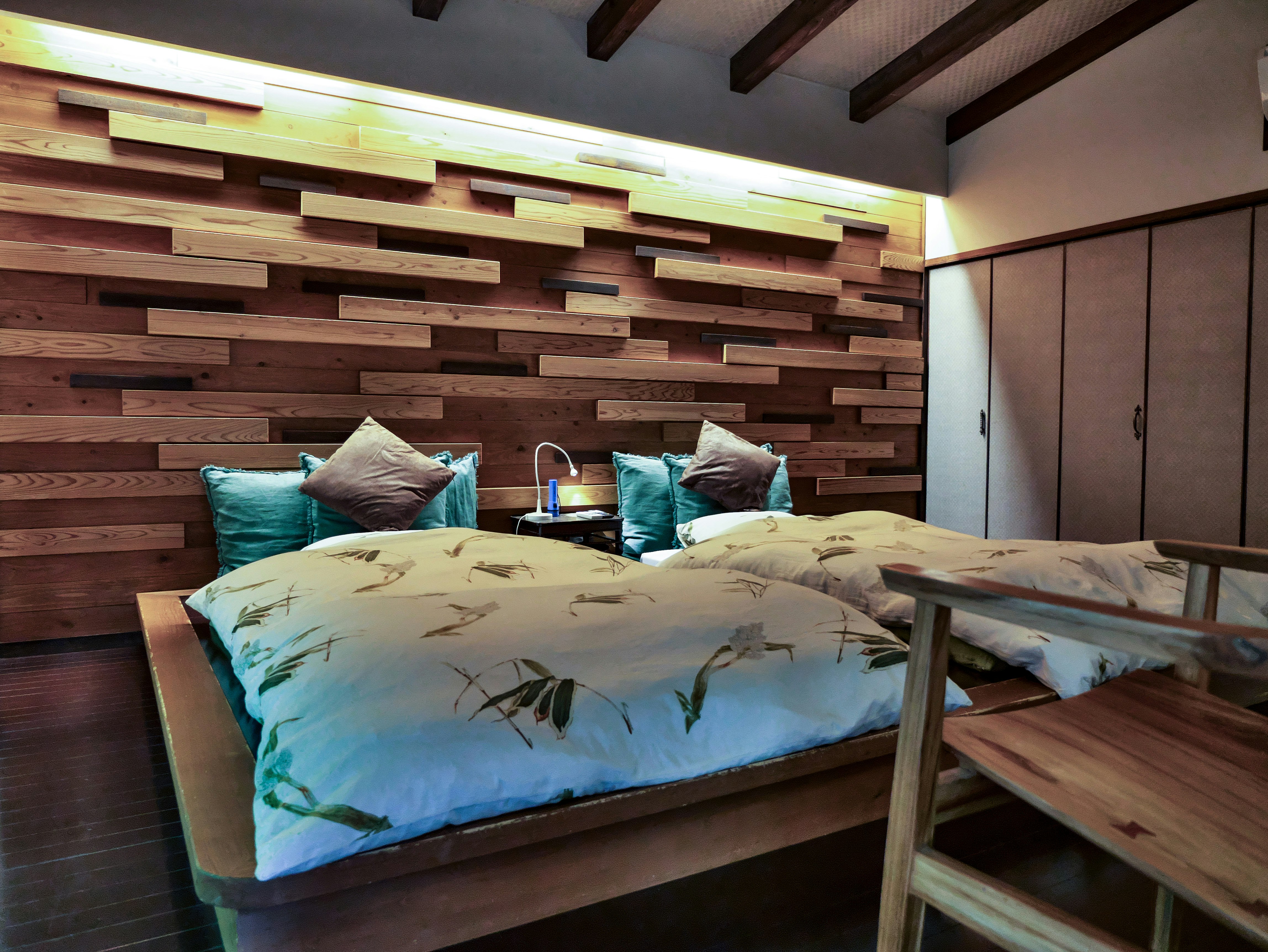tempat tidur di kamar tidur dengan dinding bilah kayu