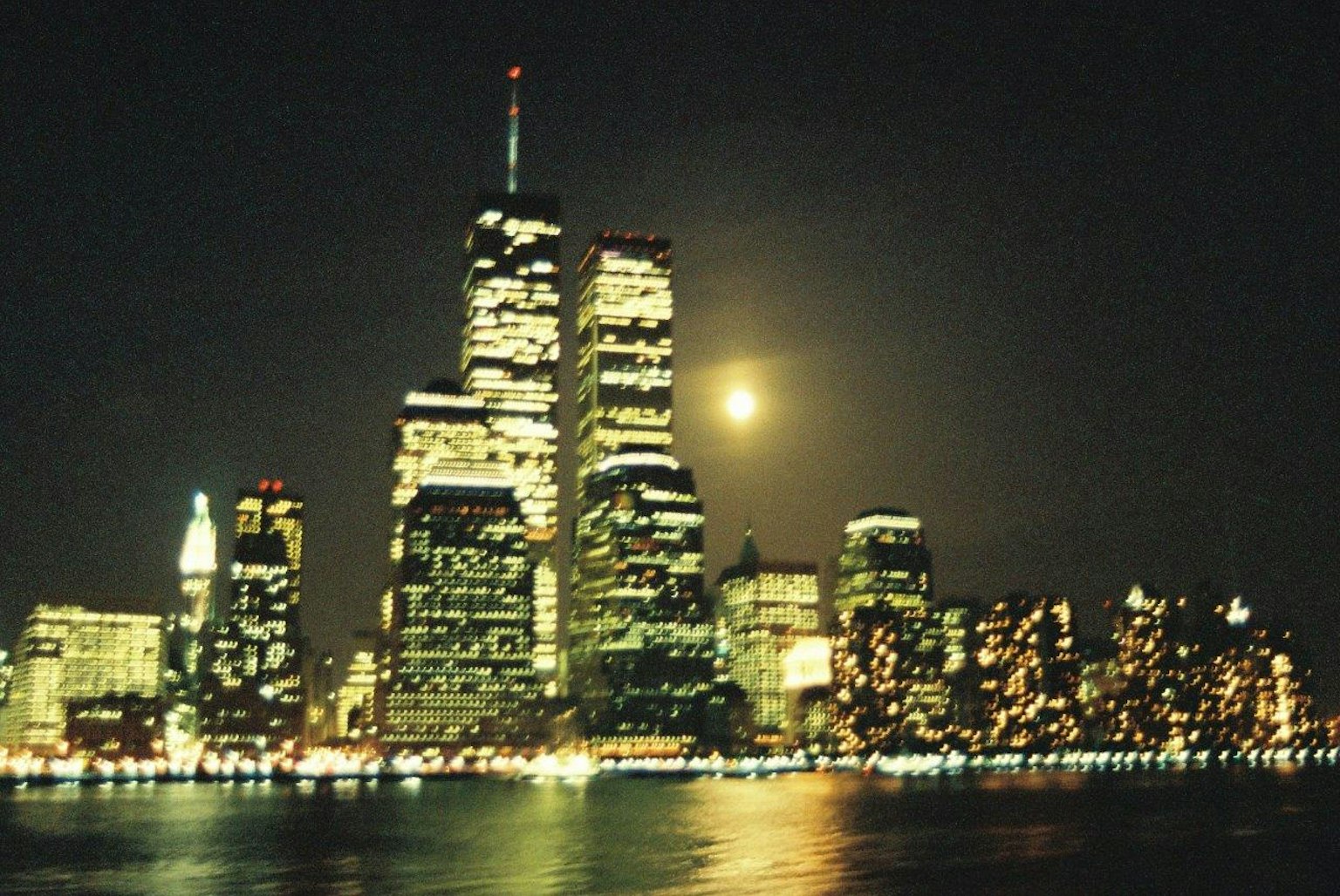 Skyline di New York di notte con le torri gemelle illuminate e una luna piena