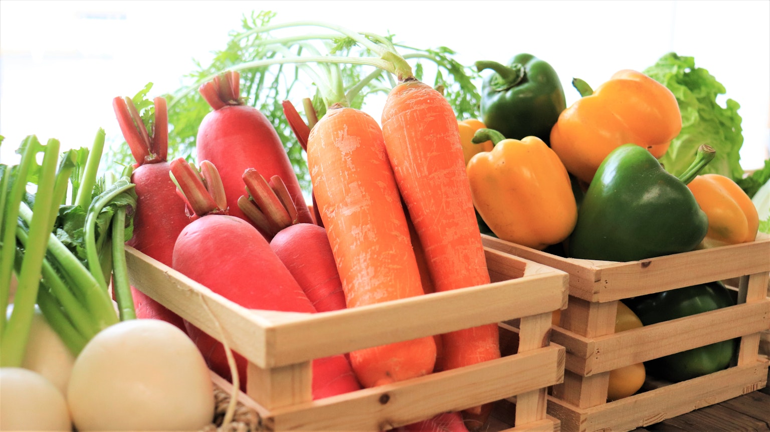 Verduras frescas en cestas de madera incluyendo zanahorias rábanos y pimientos