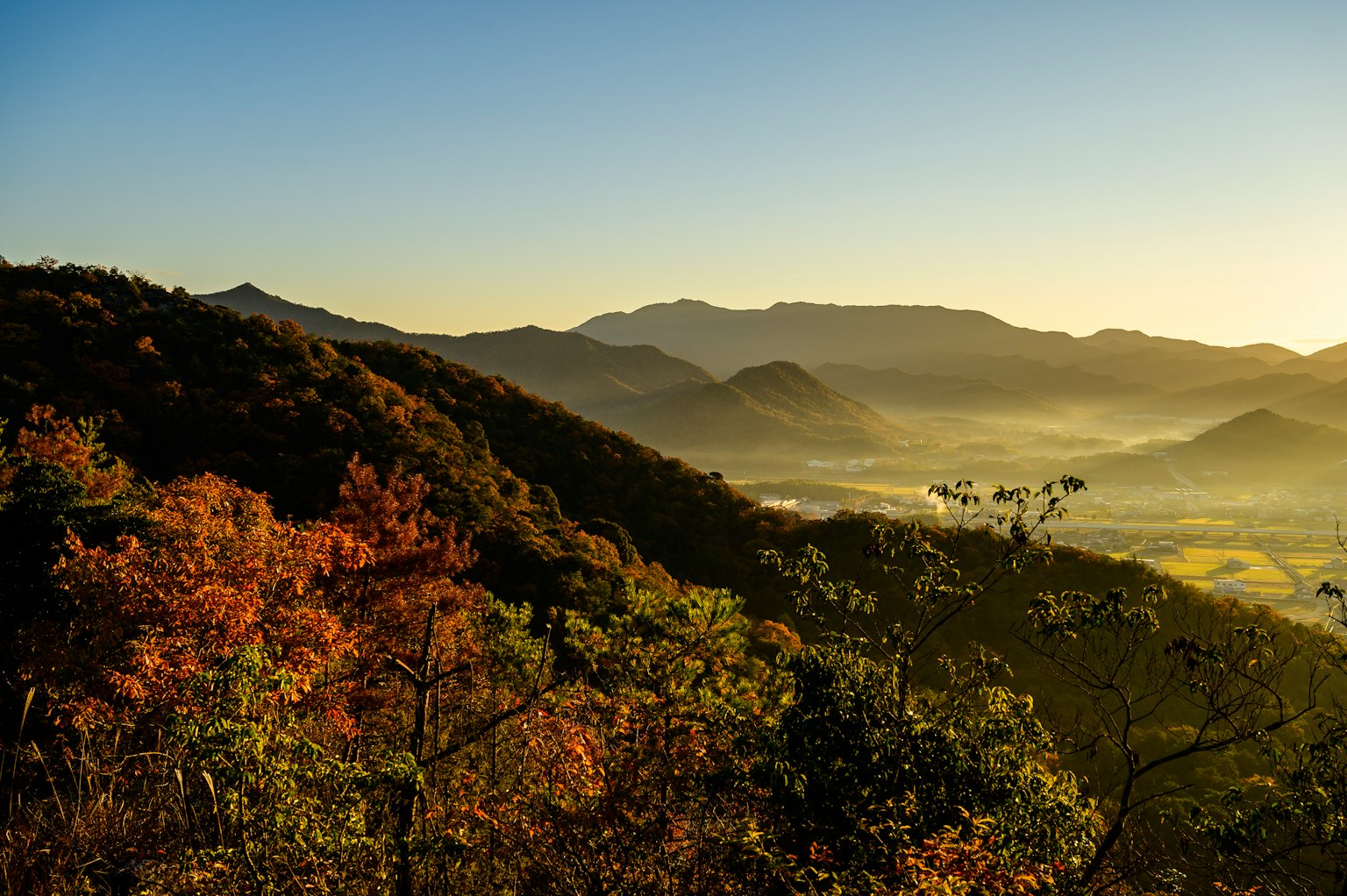 Bellissimo paesaggio montano autunnale con valle nebbiosa