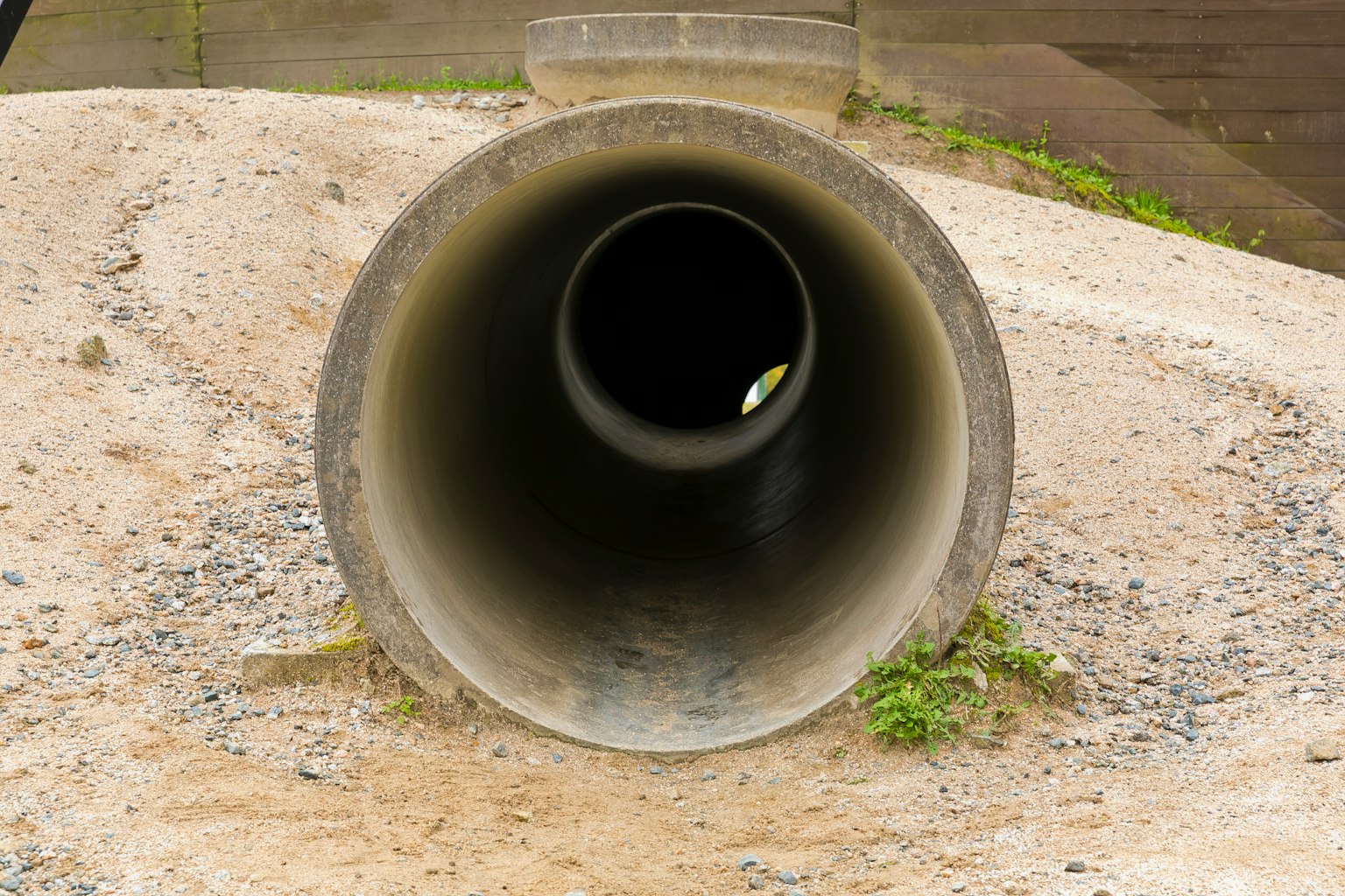 Immagine di un tubo di cemento su ghiaia con apertura visibile