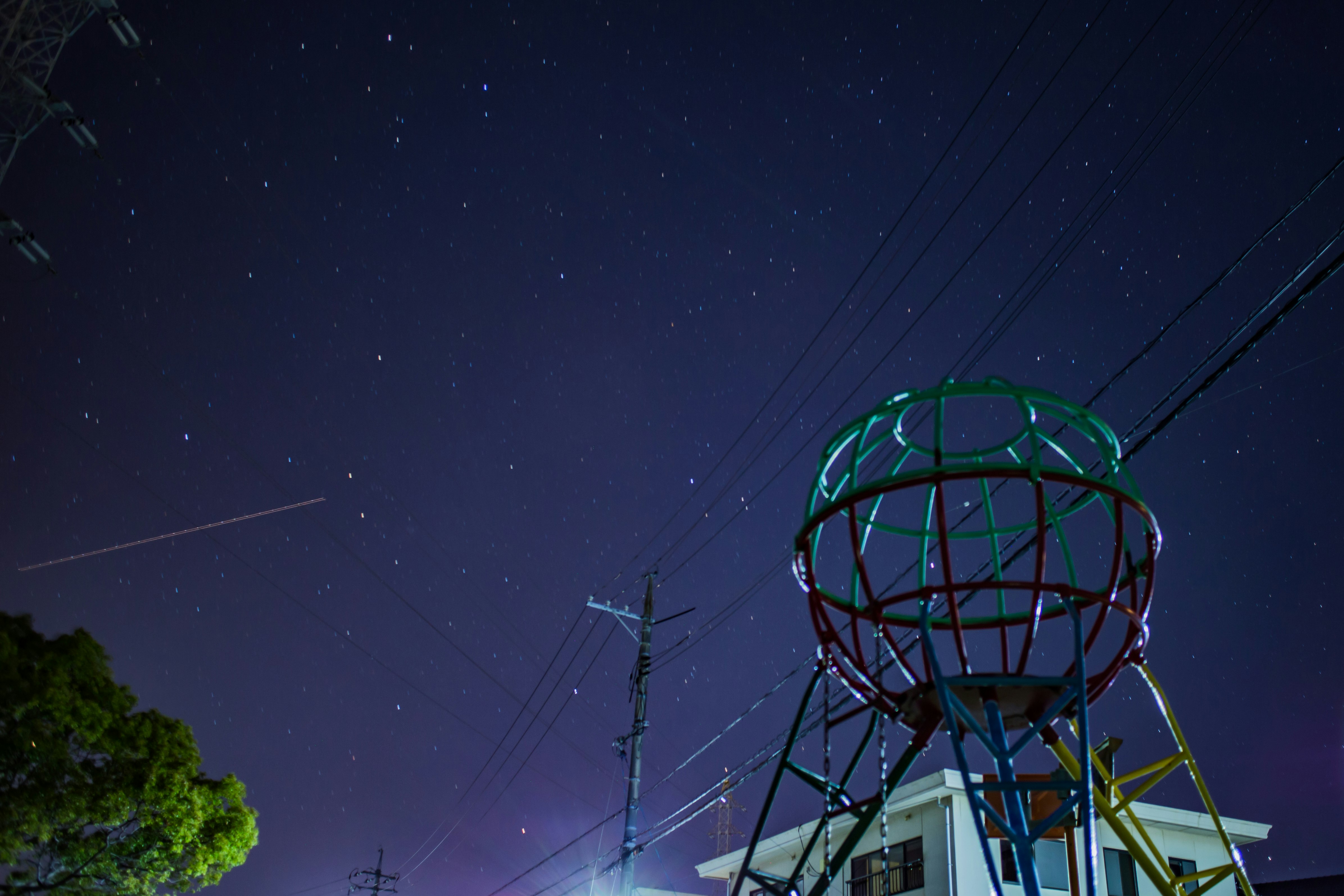 water tower and power lines under a night sky