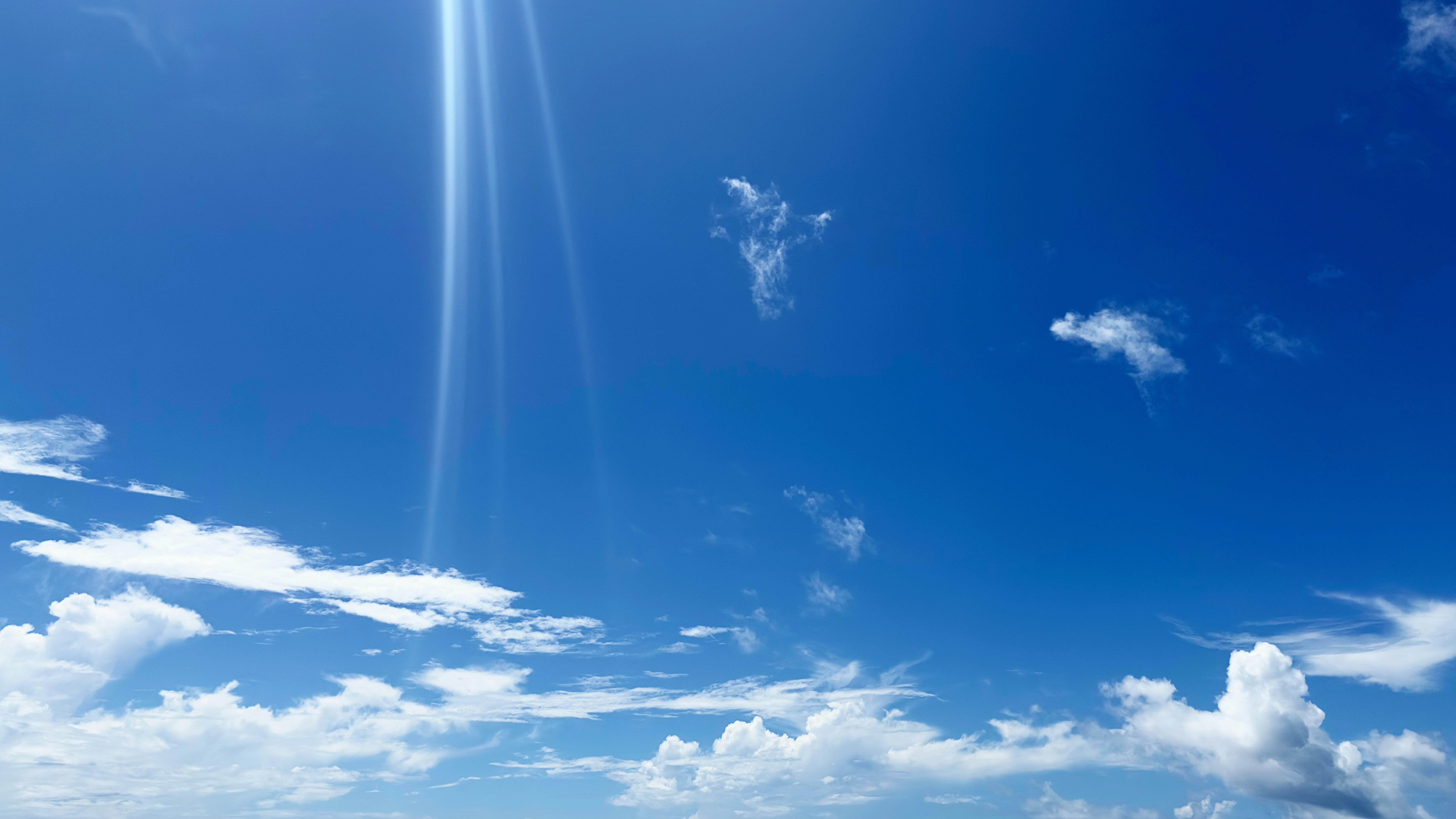 青空に伸びる光の筋と雲