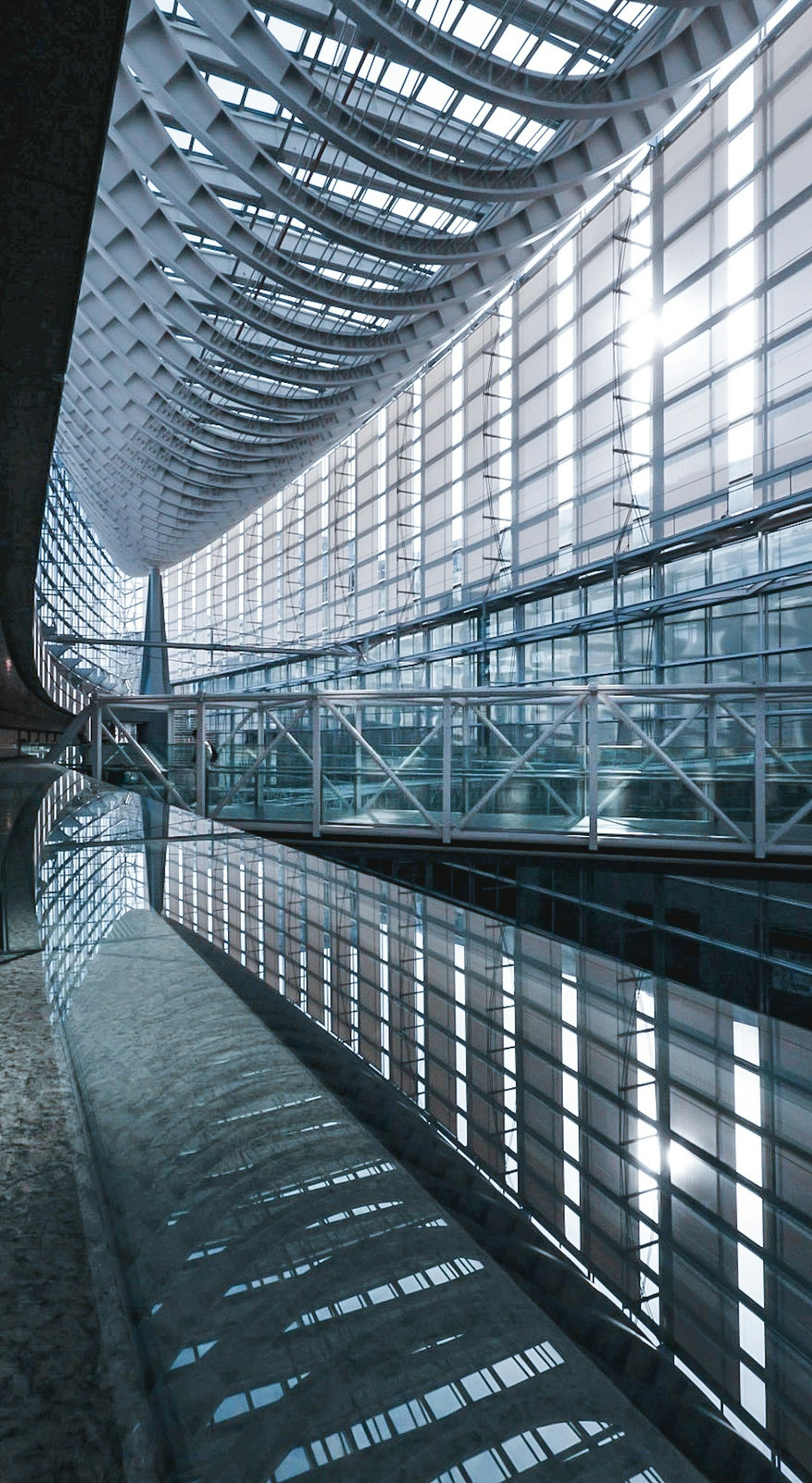 Interno di un edificio moderno con grandi finestre e riflessi di luce naturale