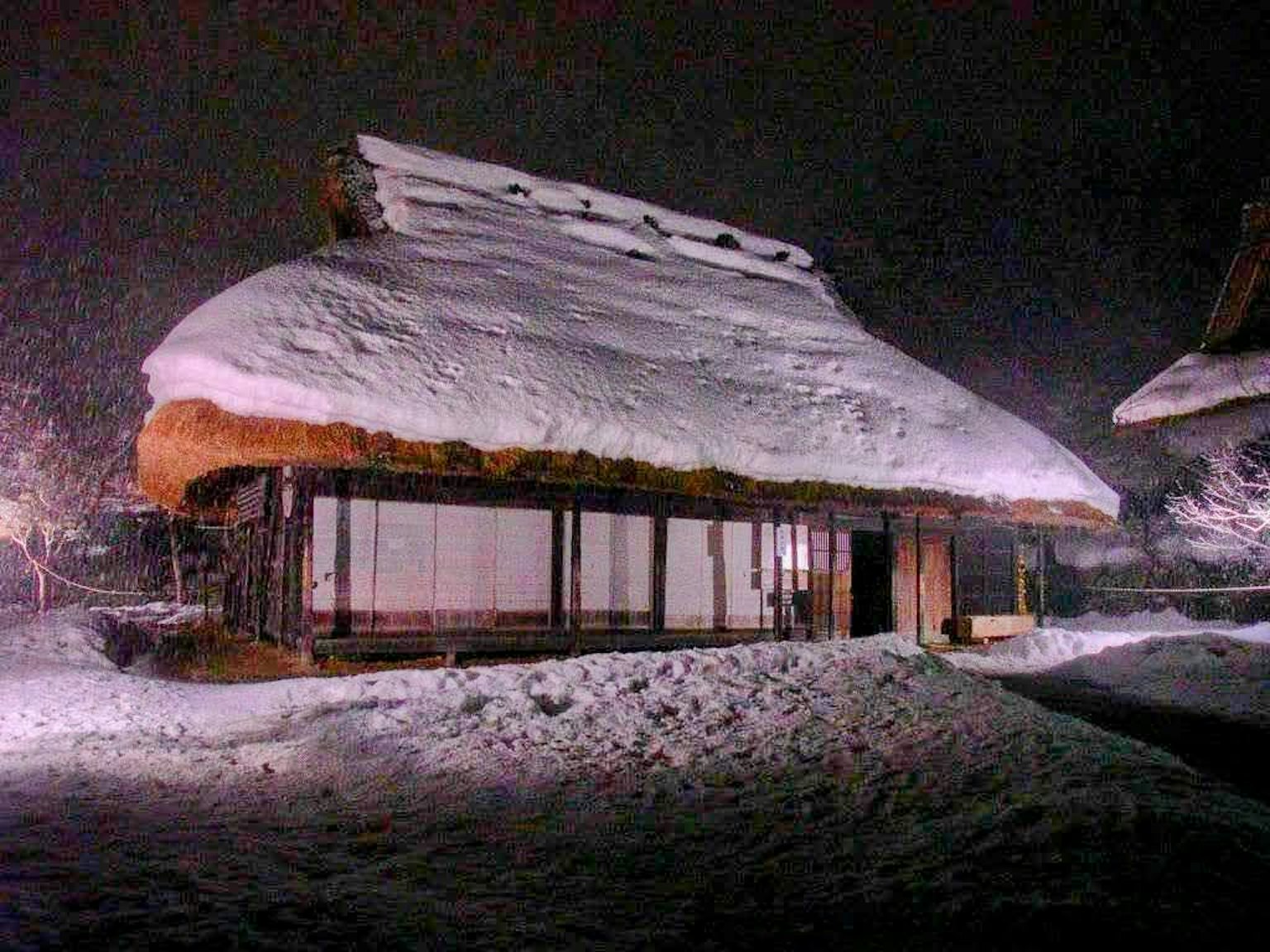 Casa giapponese tradizionale coperta di neve illuminata di notte