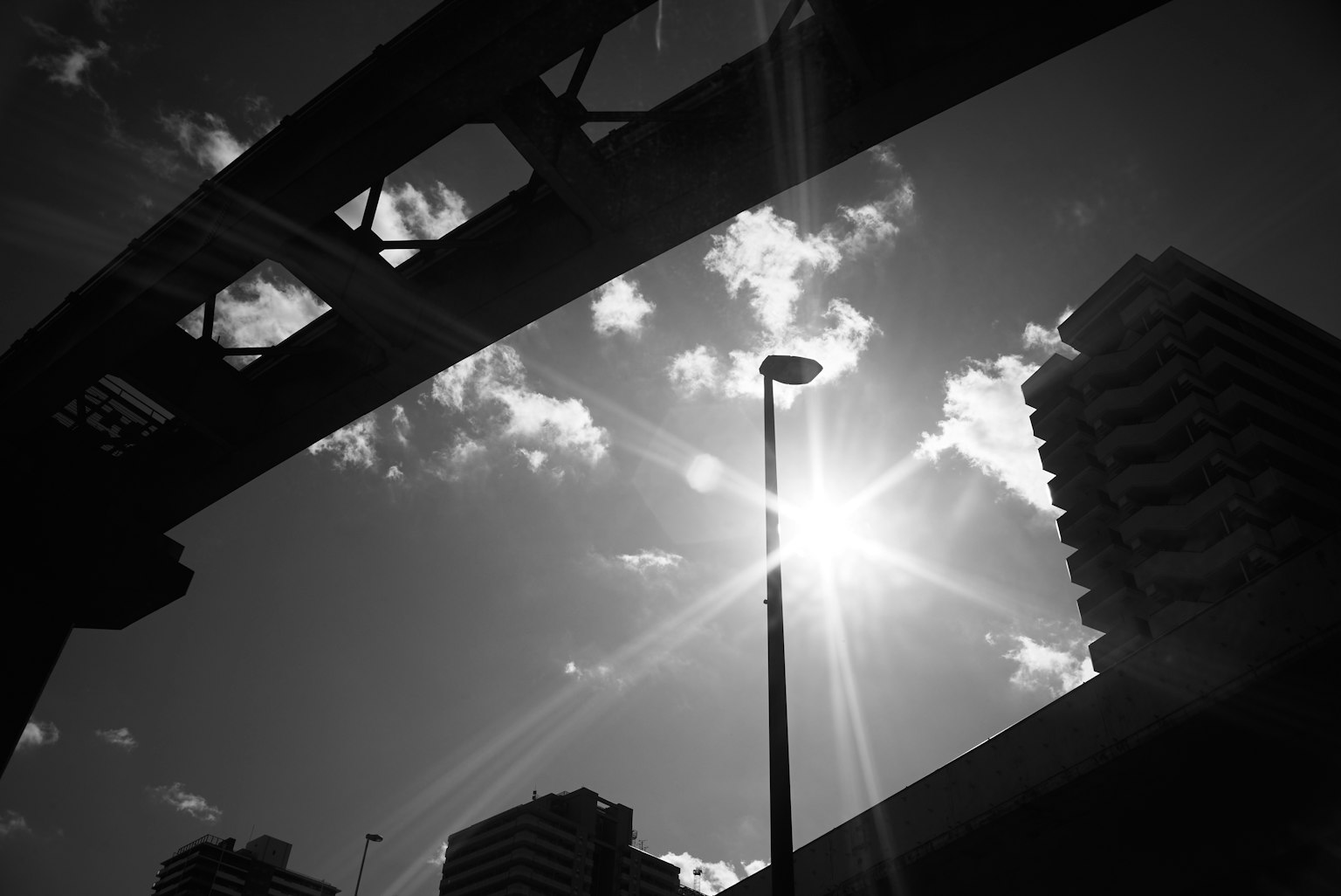 Schwarz-weiß Stadtlandschaft mit Sonnenlicht und Gebäudesilhouetten