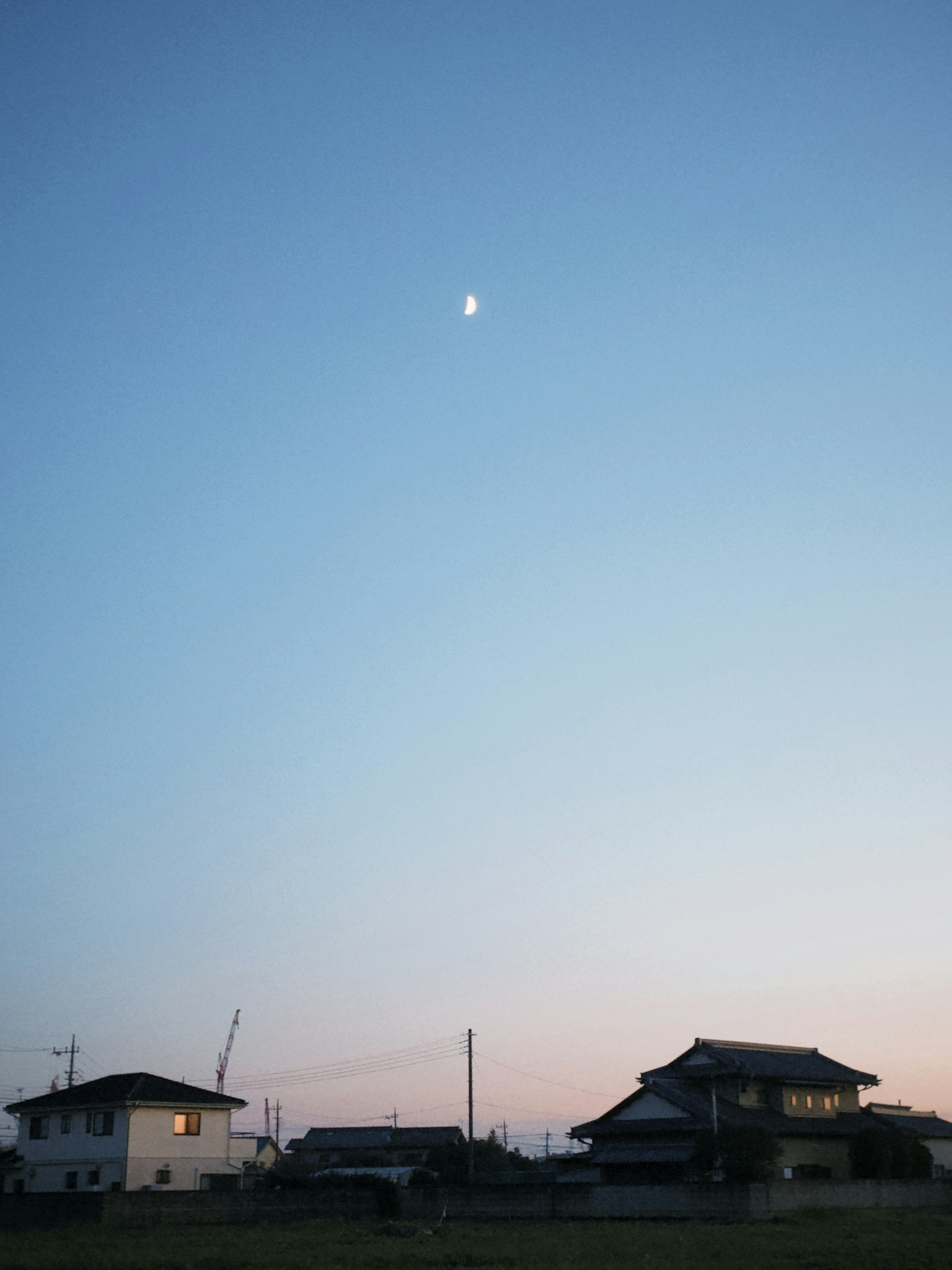 Luna nel cielo serale sopra le case