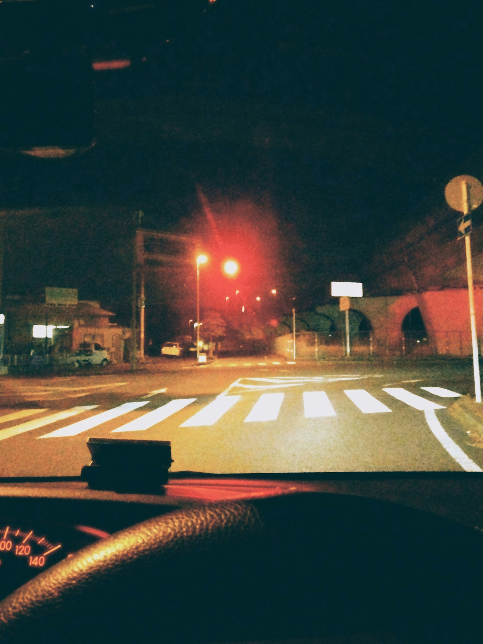 夜間交叉口的紅燈和人行道的影像