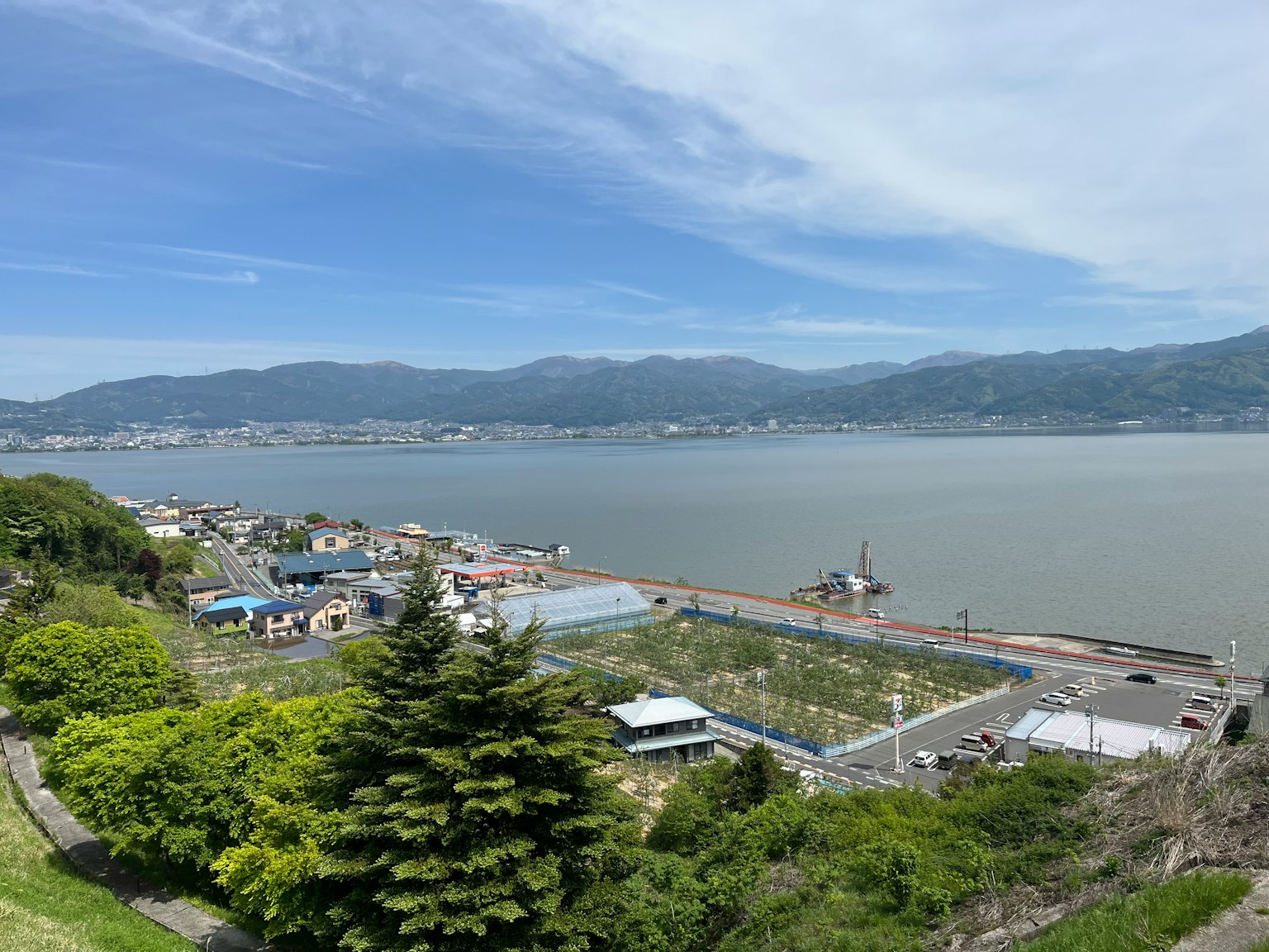 Panoramablick auf eine Küstenstadt mit Bergen im Hintergrund