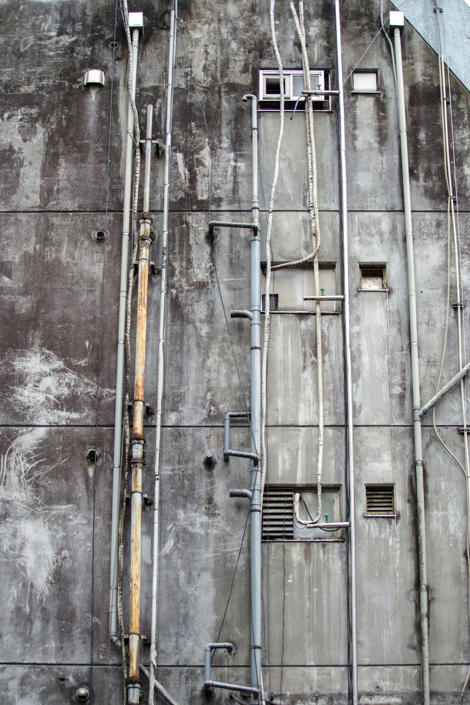 Vue détaillée des tuyaux et des câbles fixés à un mur en béton