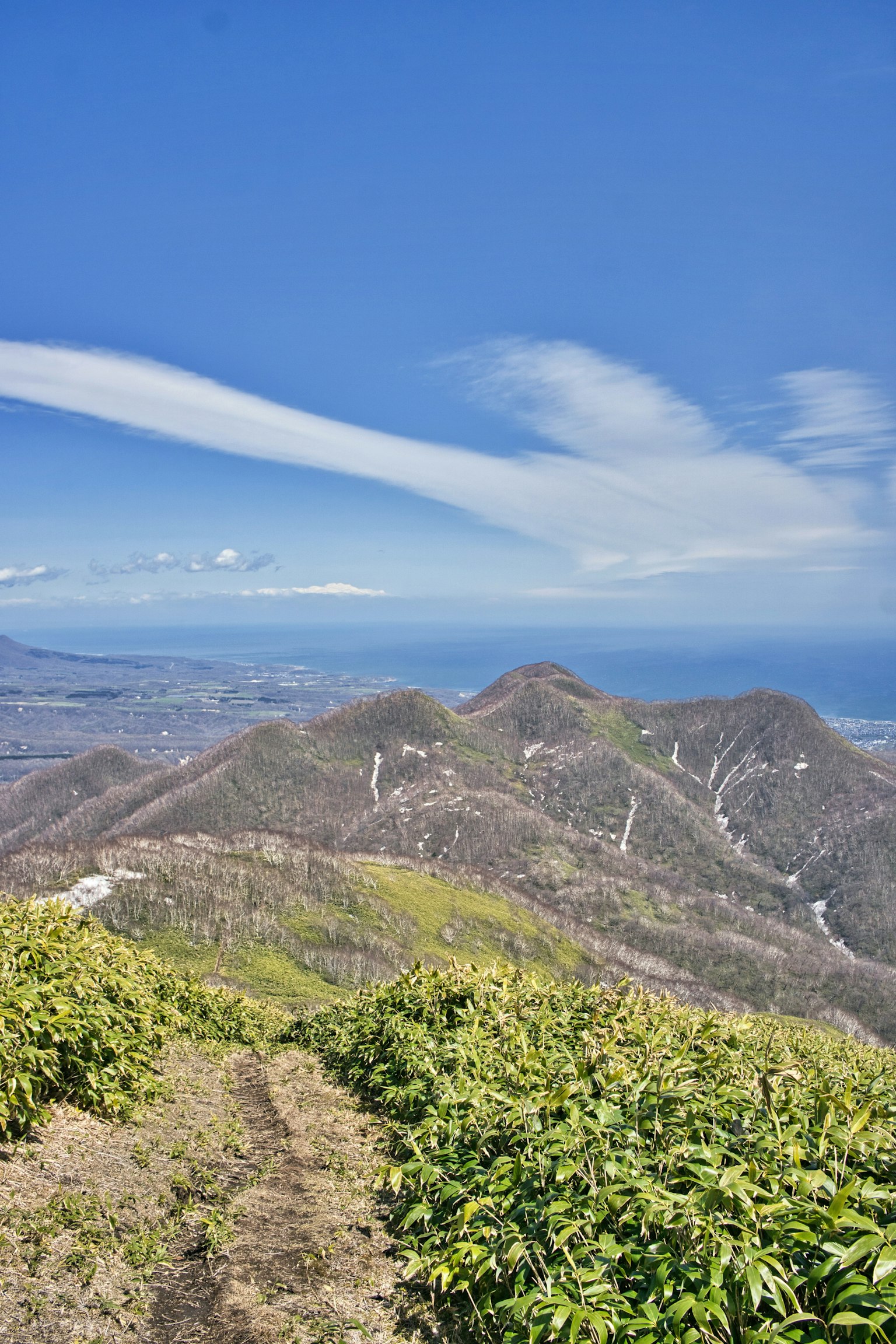 Scenic view of mountains and ocean under a blue sky