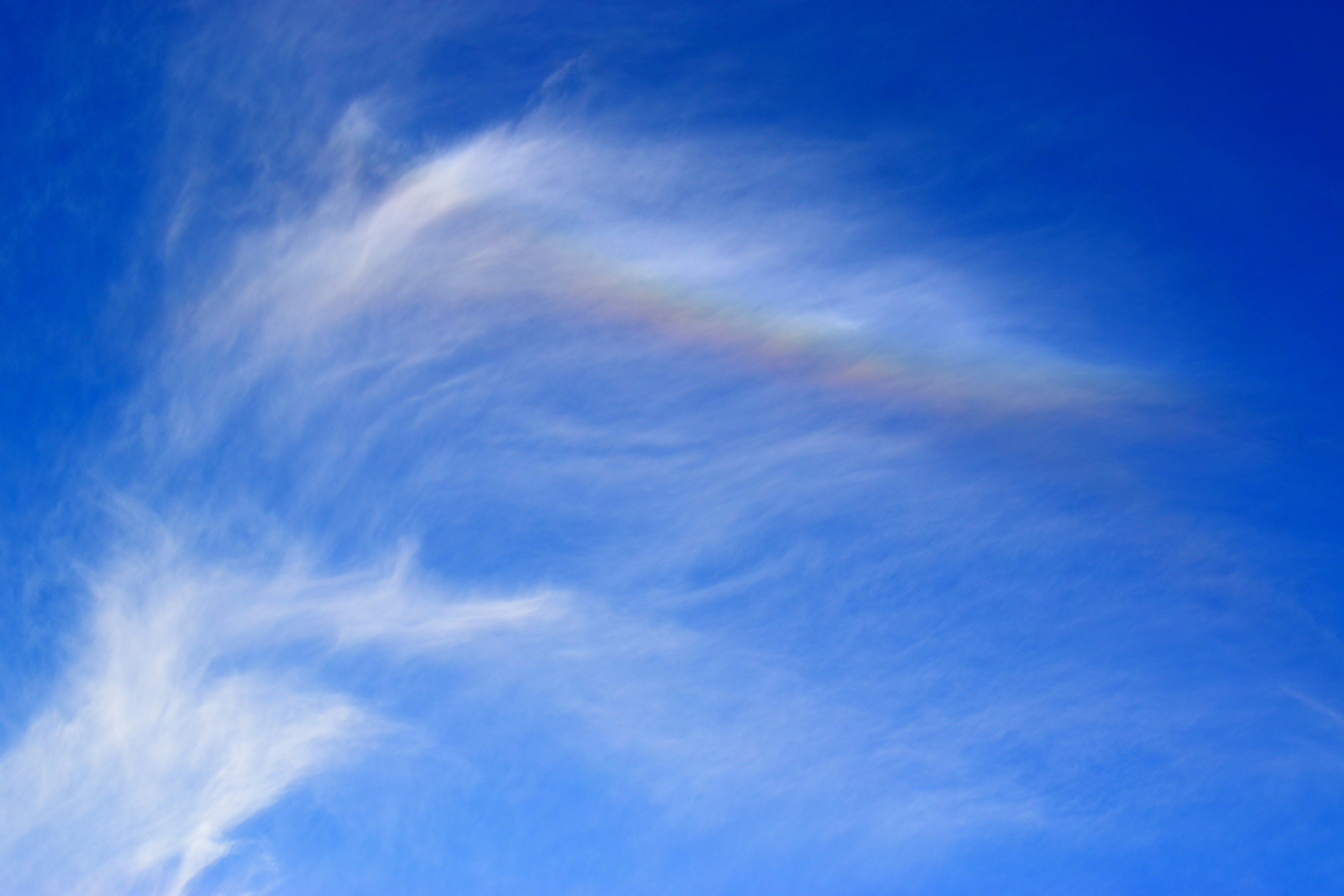 虹色の雲が広がる青空