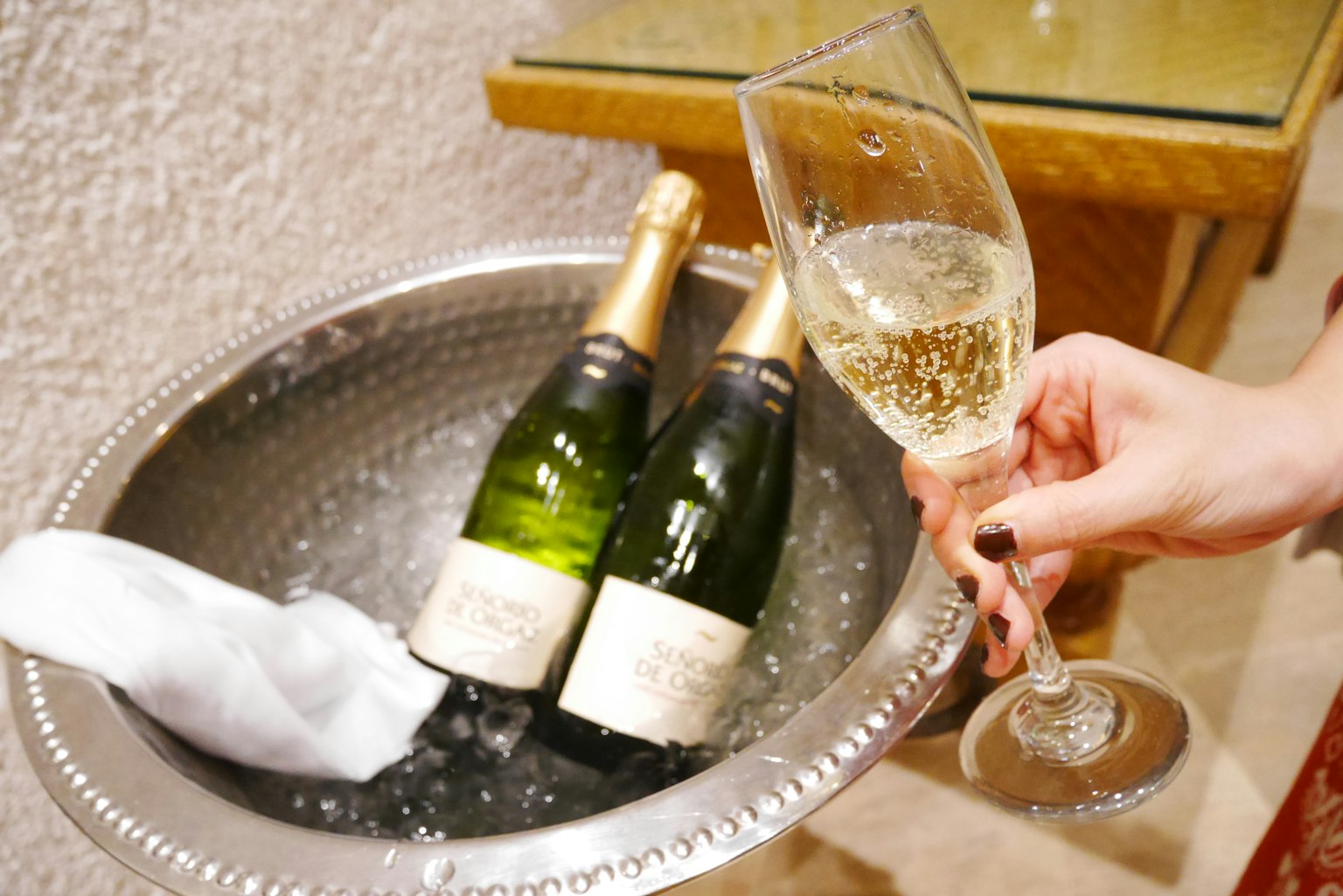 Bouteilles de champagne refroidies dans un seau à glace avec un verre en train d'être servi