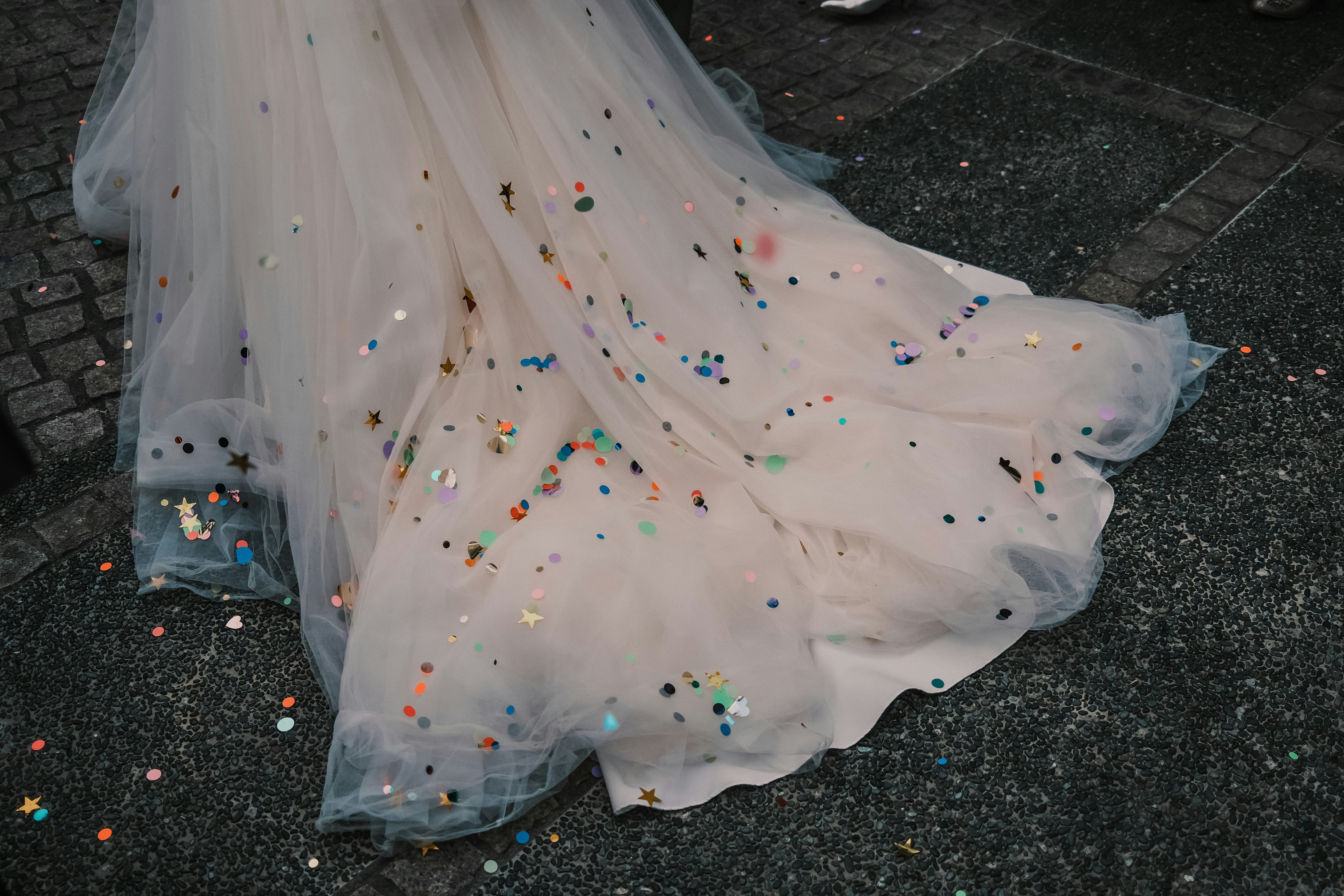 white fabric scattered with colorful confetti on pavement