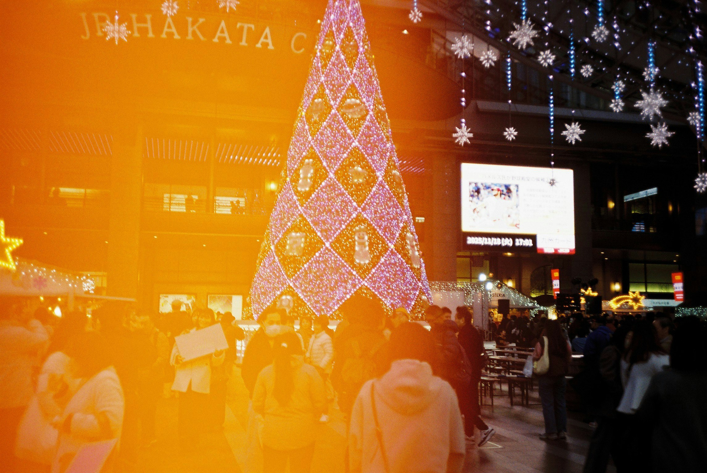 光るクリスマスツリーとイルミネーションのある夜の街並み