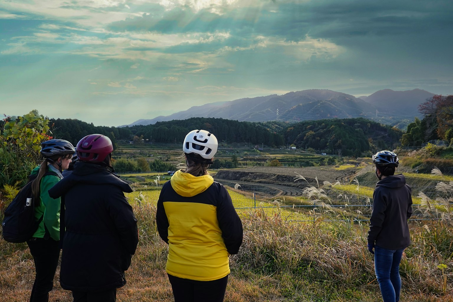 Un gruppo con caschi da ciclismo osserva un paesaggio montano