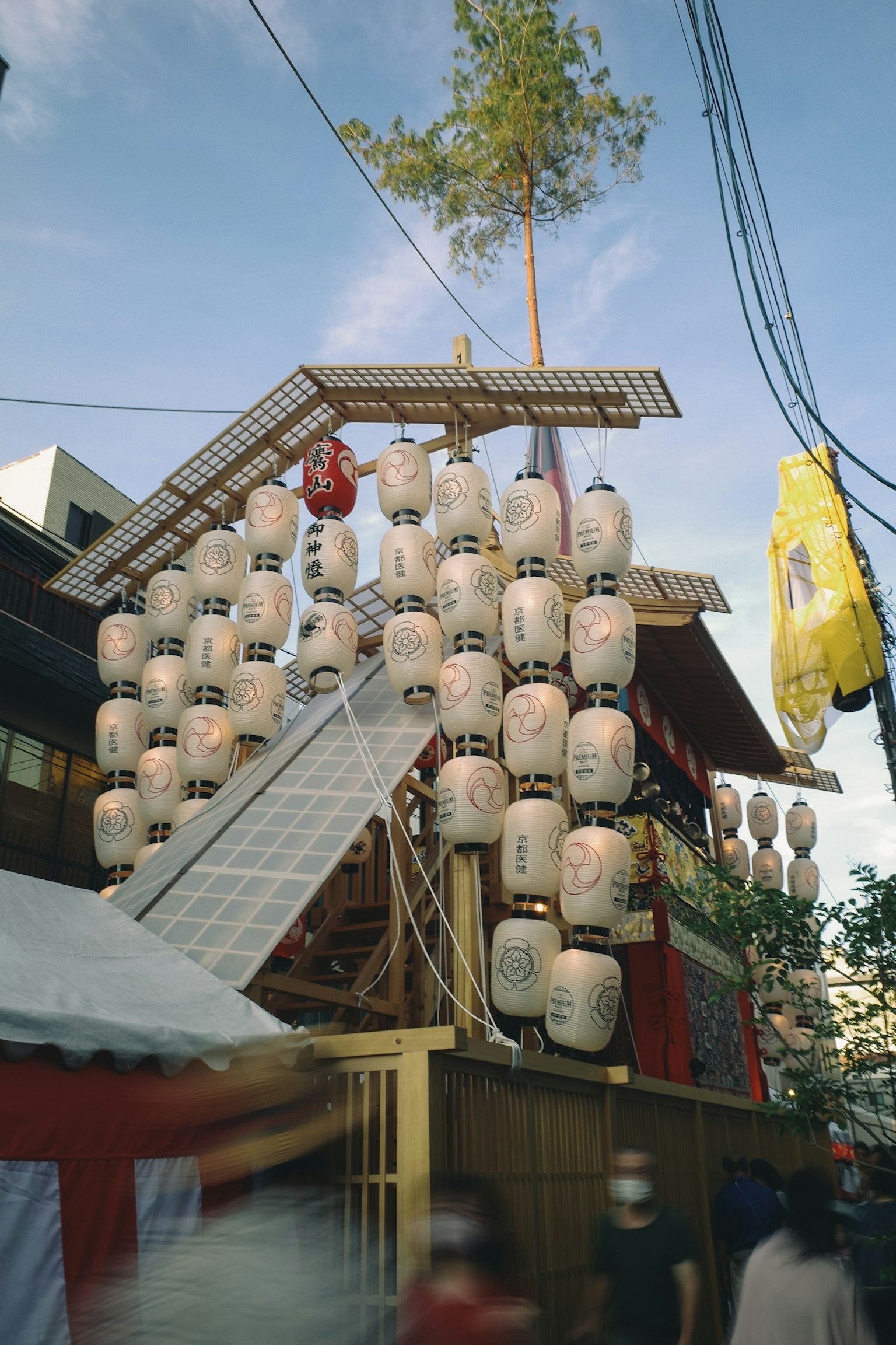 Carroza de festival decorada con faroles y un árbol en un entorno urbano