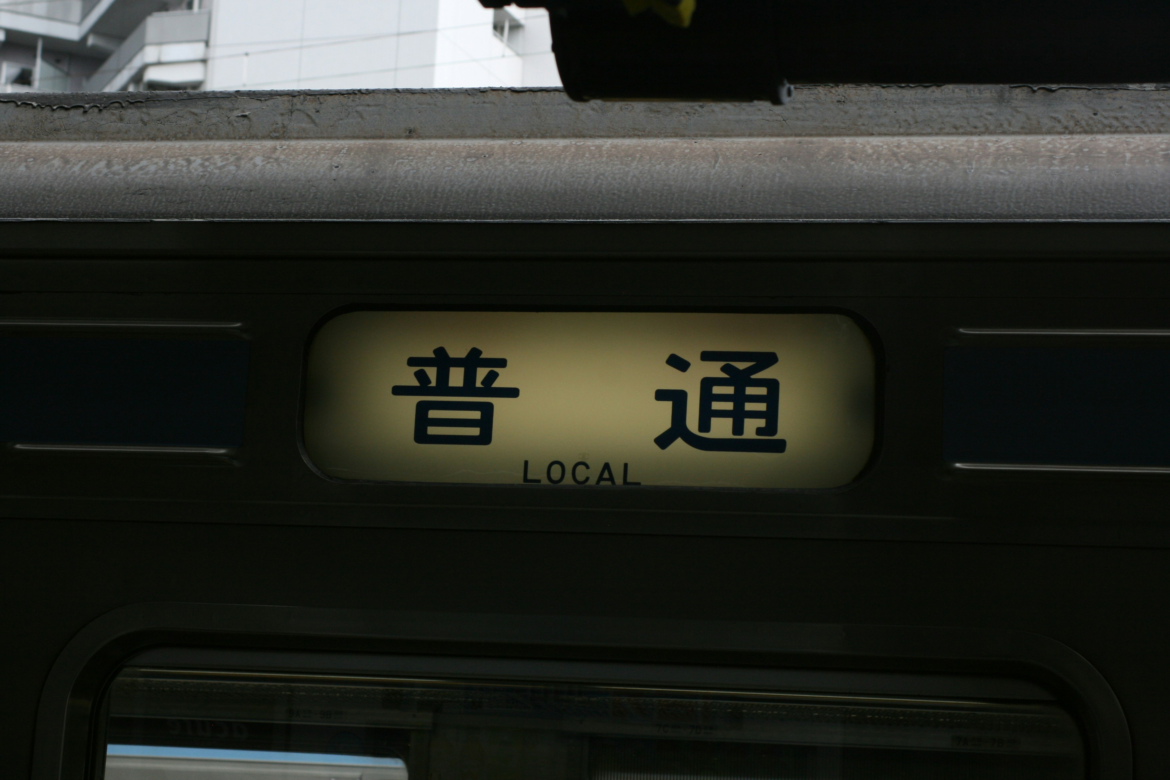 train interior door area with a “LOCAL” sign