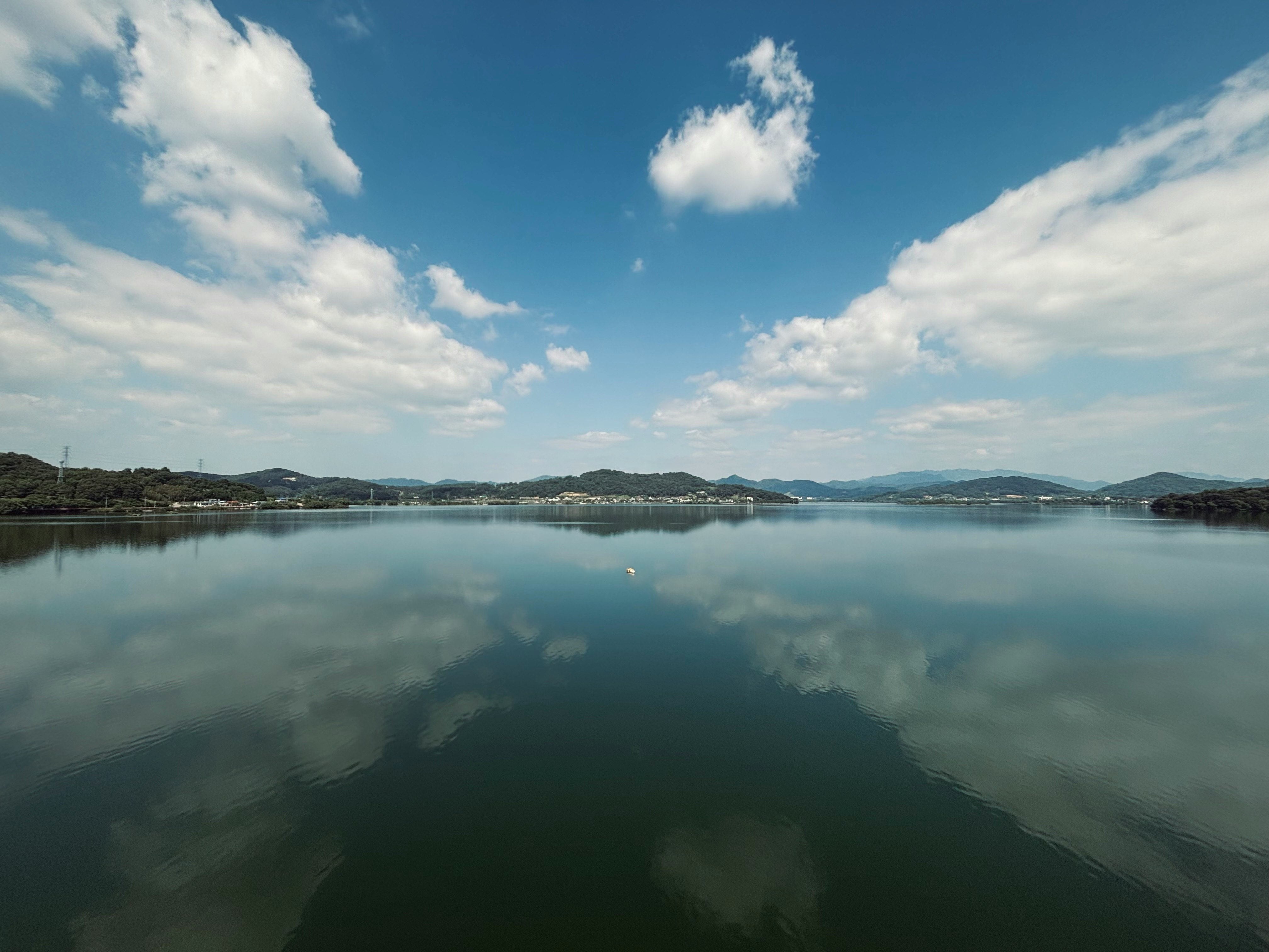lago calmo con riflessi e catena montuosa in lontananza