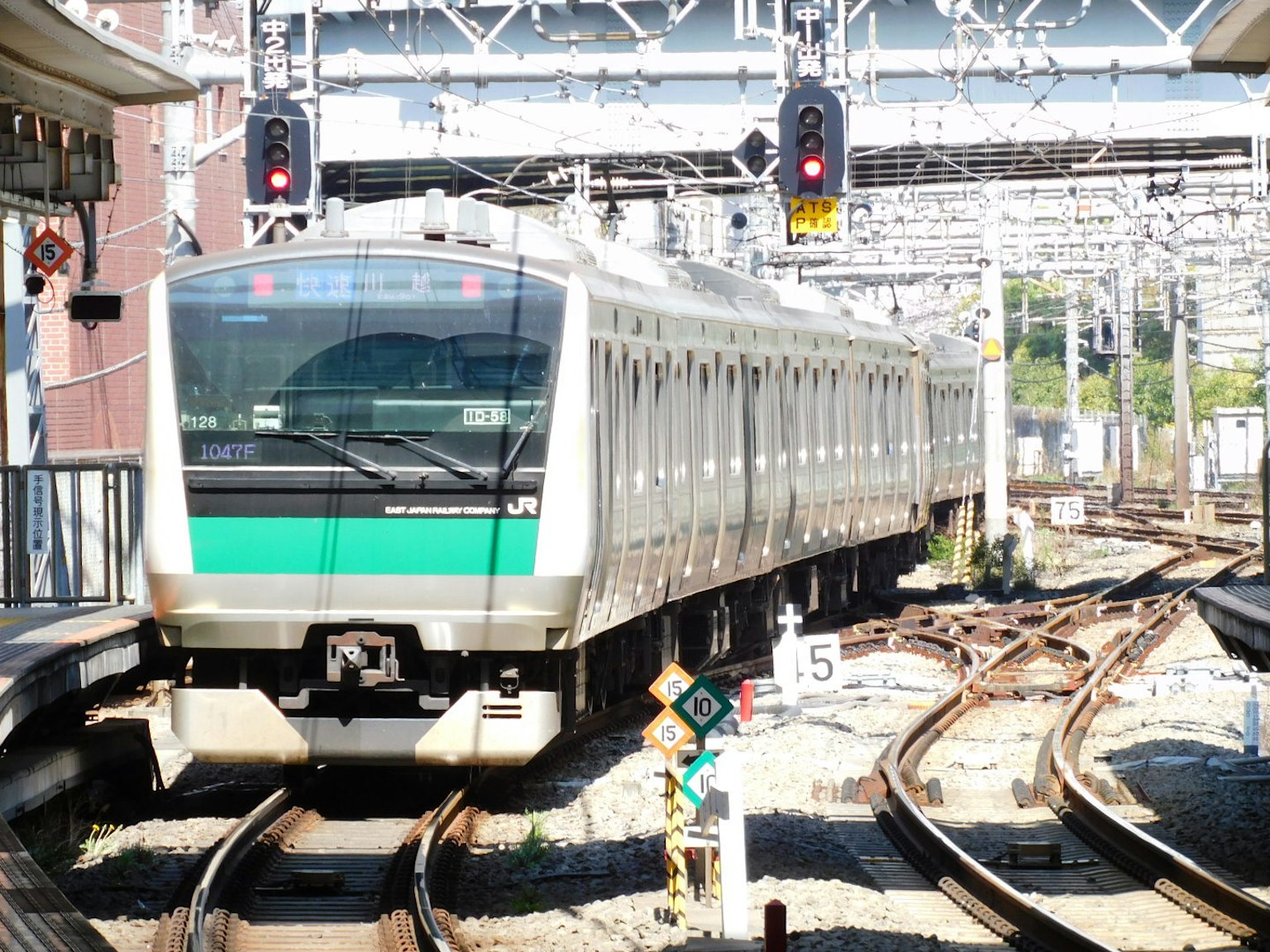 รถไฟที่มีแถบสีเขียวมาถึงสถานี
