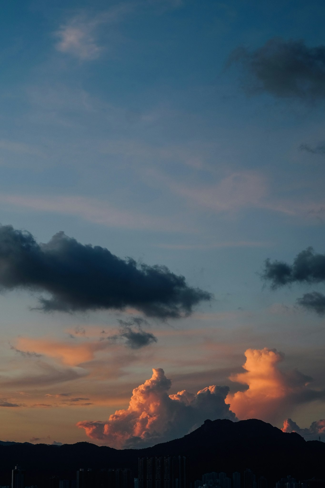 mountain silhouette against a sunset sky with clouds