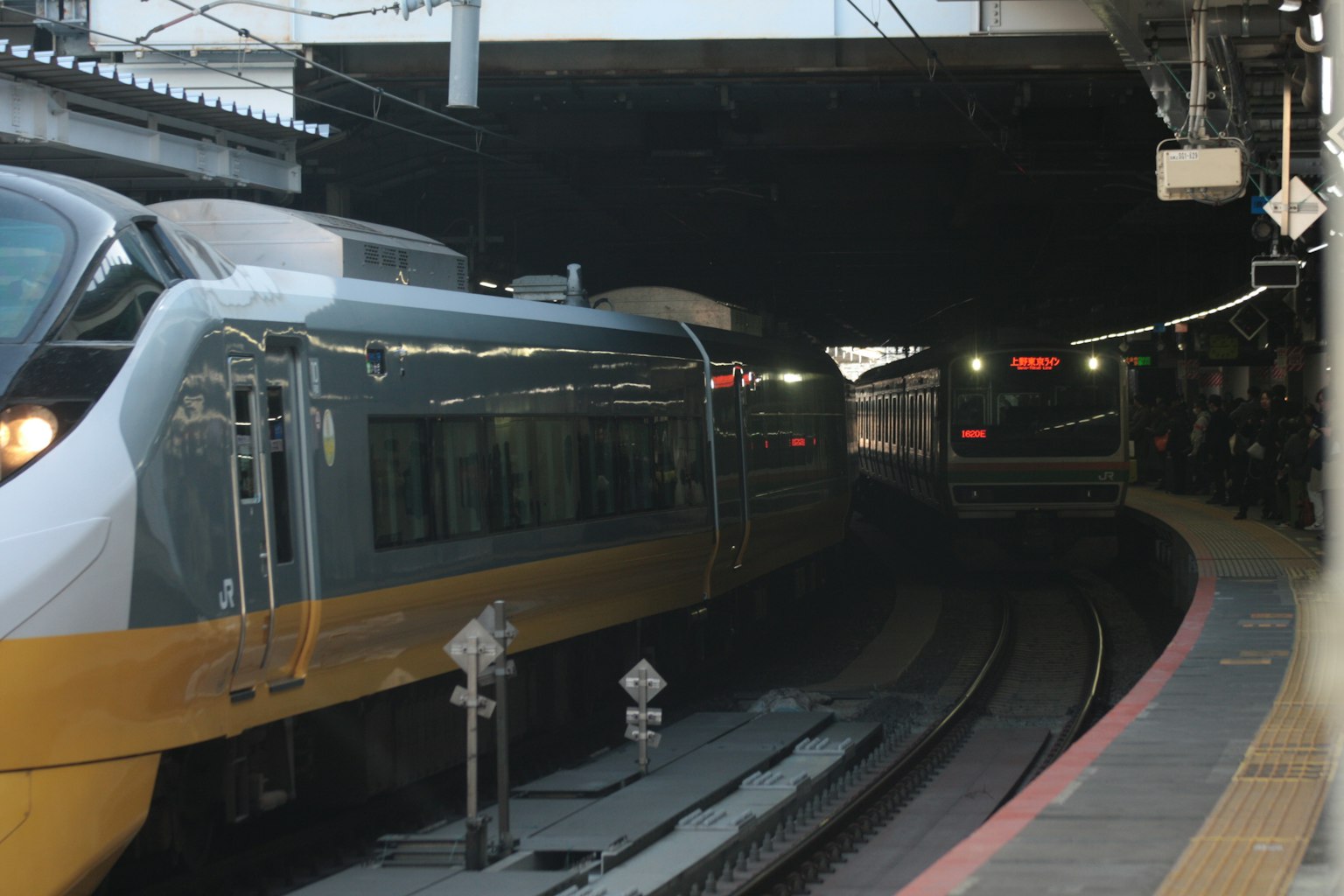 Trains entrant dans un tunnel avec des voitures jaunes et argentées