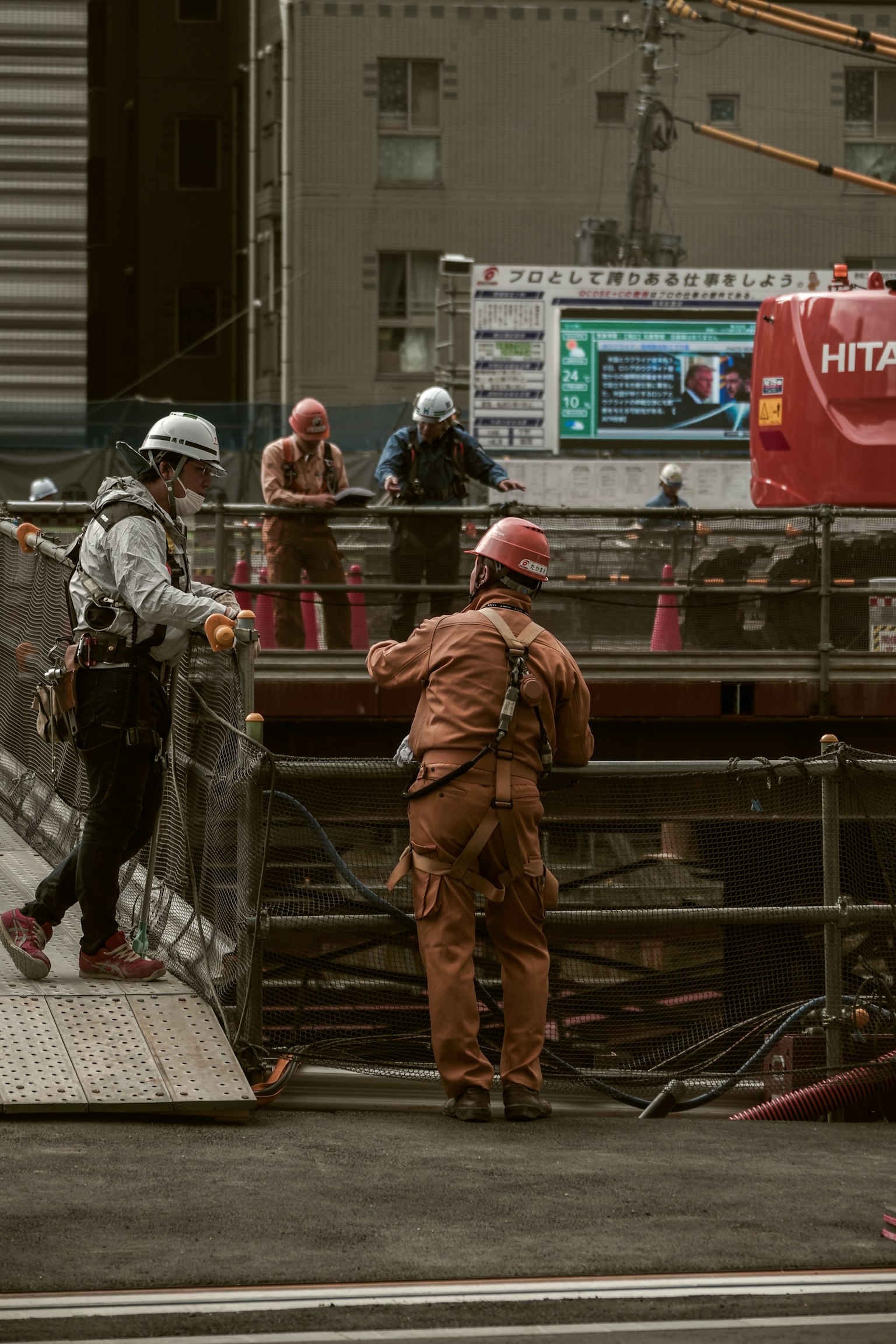 Construction workers at a site wearing helmets and safety vests