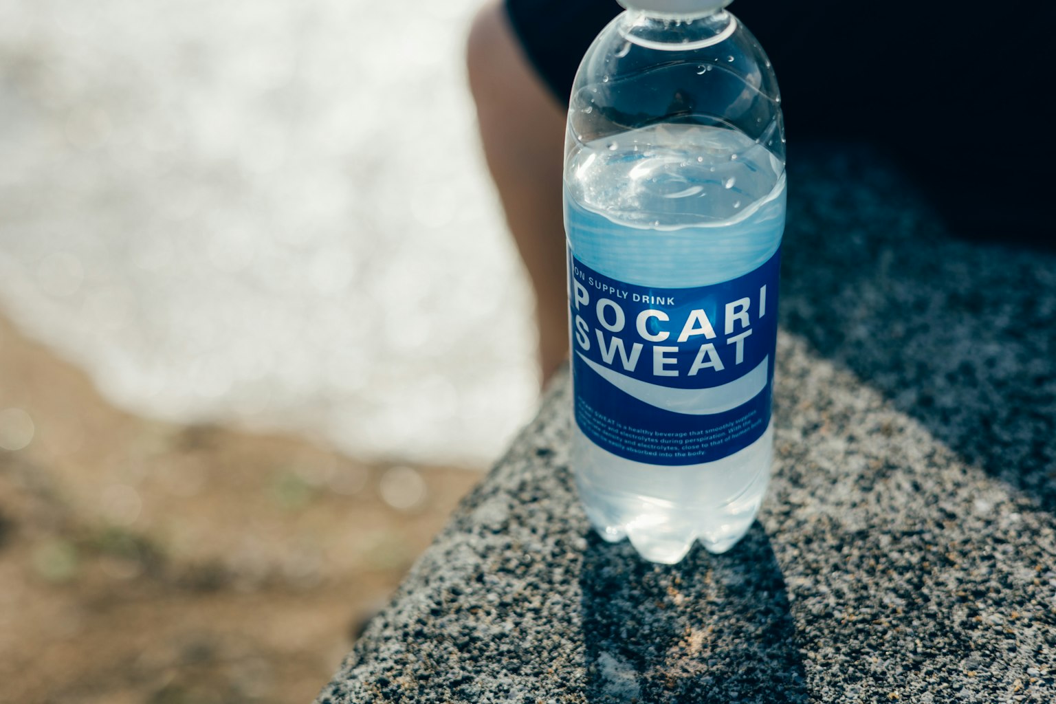 Bouteille de Pocari Sweat posée sur une surface en pierre
