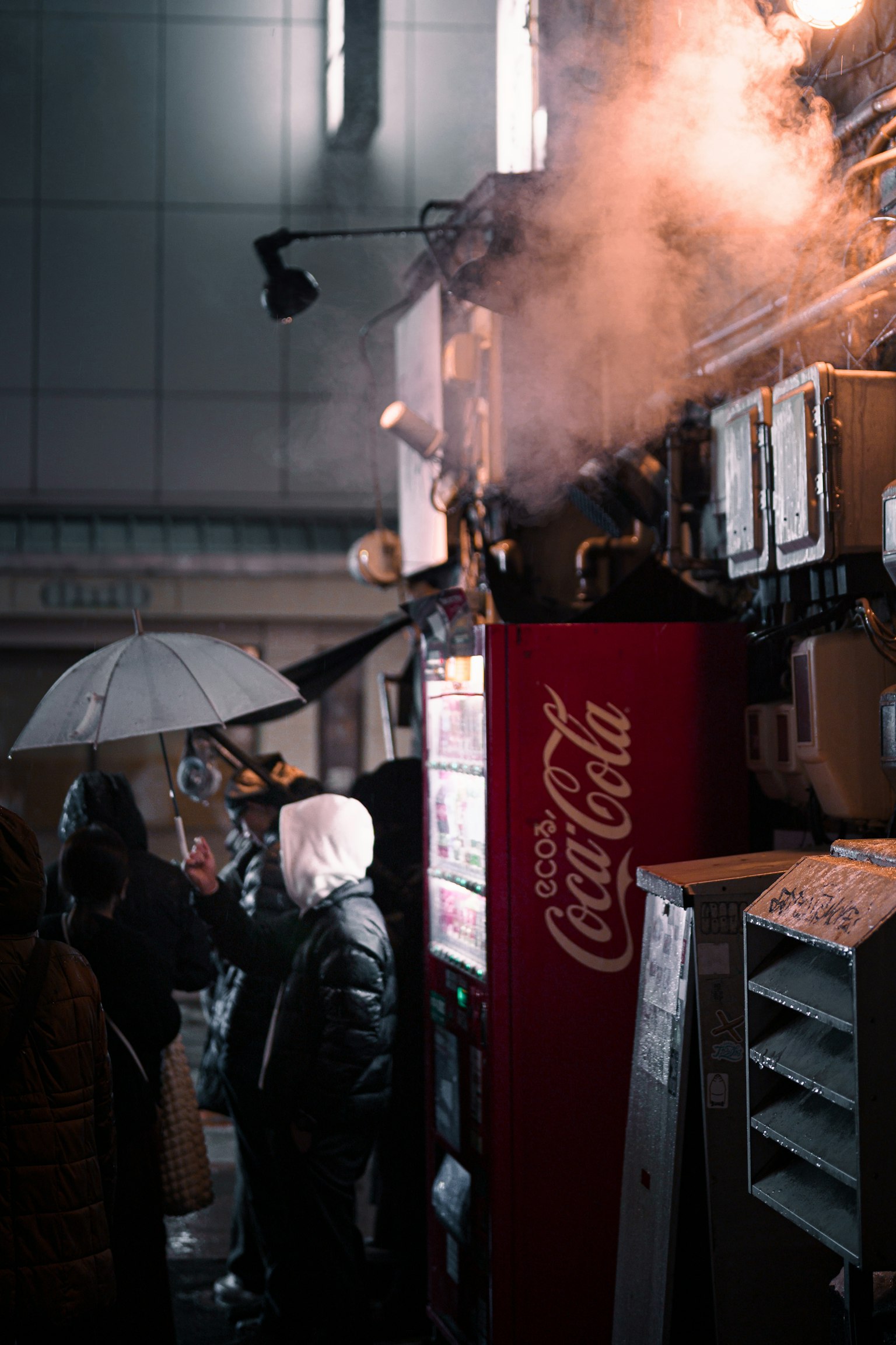Scena di strada con un distributore automatico Coca-Cola e vapore che sale
