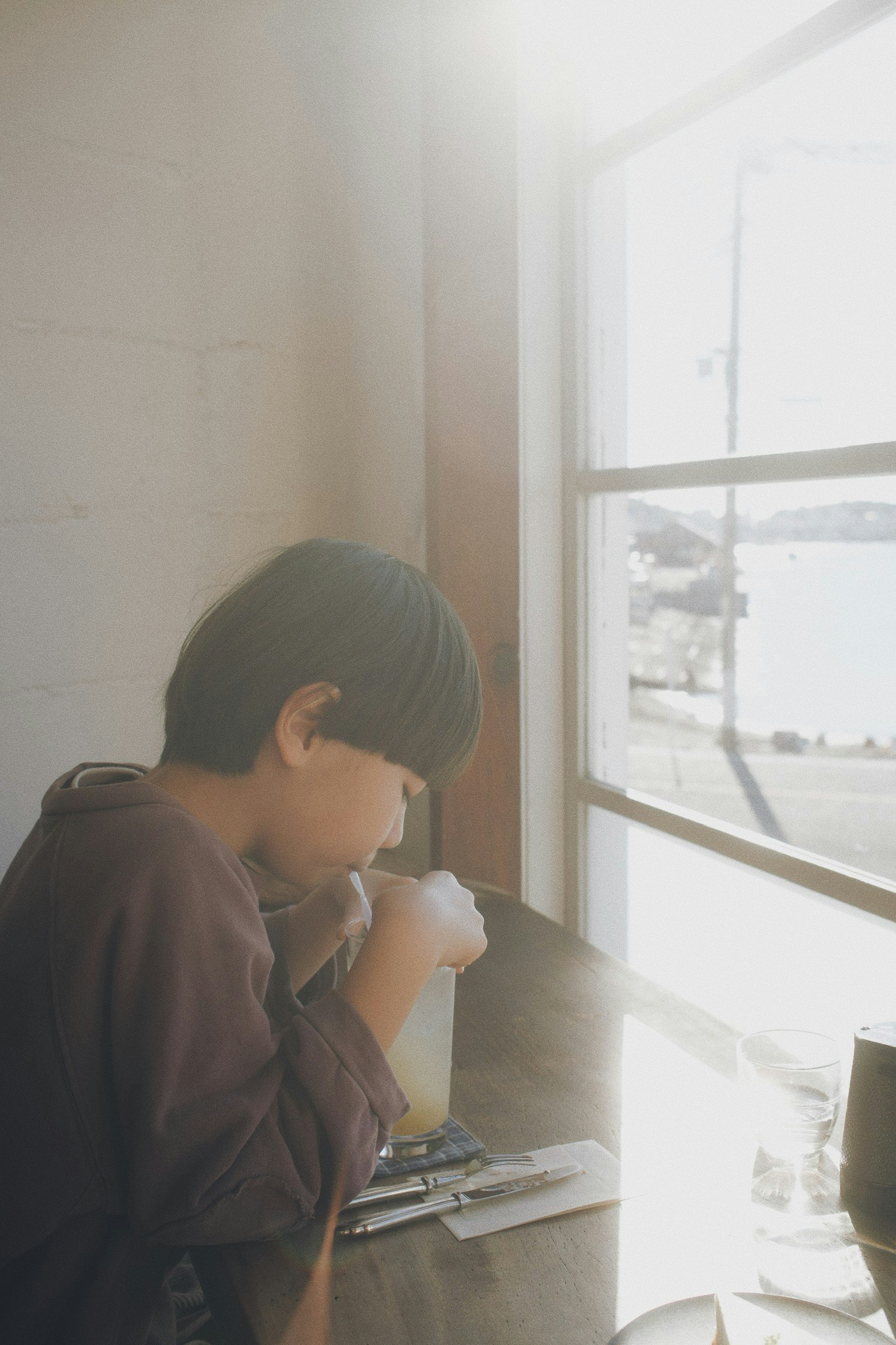 窓辺でノートを見つめる人物の横顔
