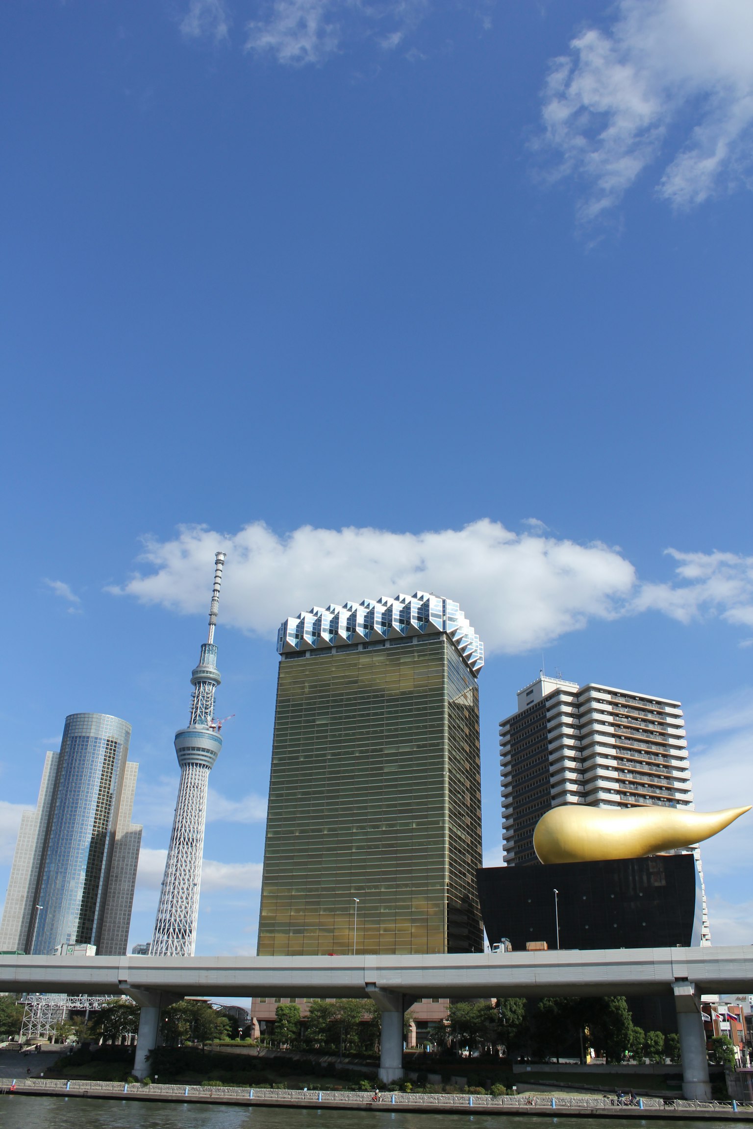 Pemandangan kota dengan Tokyo Skytree dan Menara Bir Asahi di bawah langit biru
