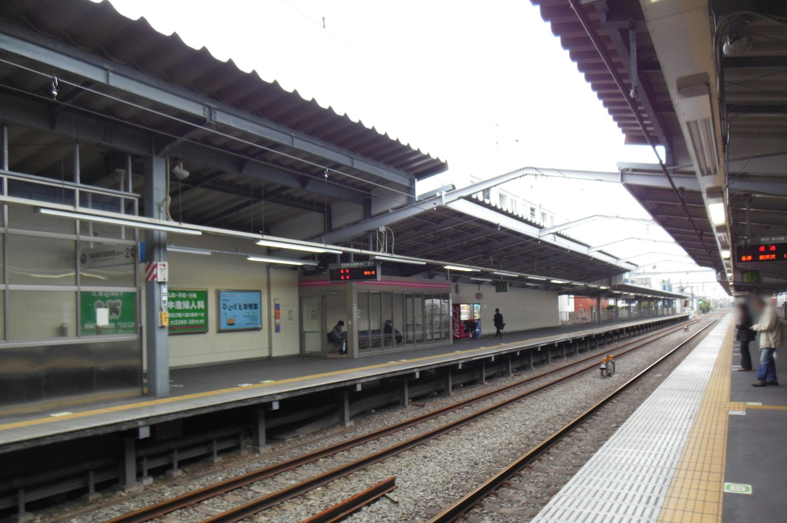 View of a train station platform with tracks