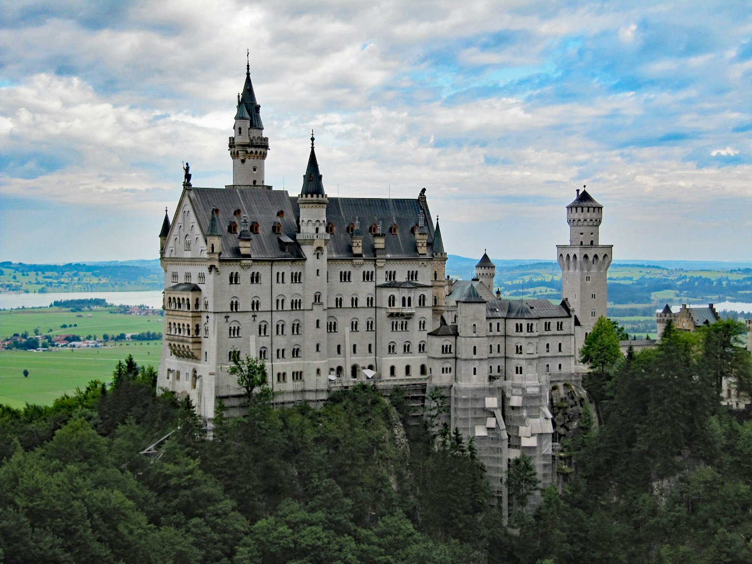 Lâu đài Neuschwanstein vươn lên trên rừng xanh và phong cảnh