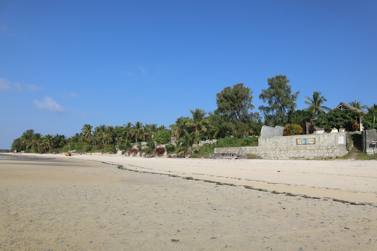 ทิวทัศน์ชายหาดที่มีท้องฟ้าสีฟ้าและชายฝั่งทราย