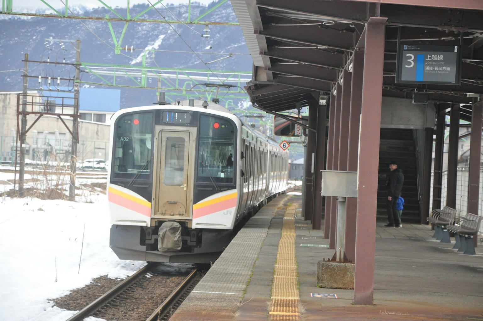 Treno fermo in una stazione innevata con una banchina